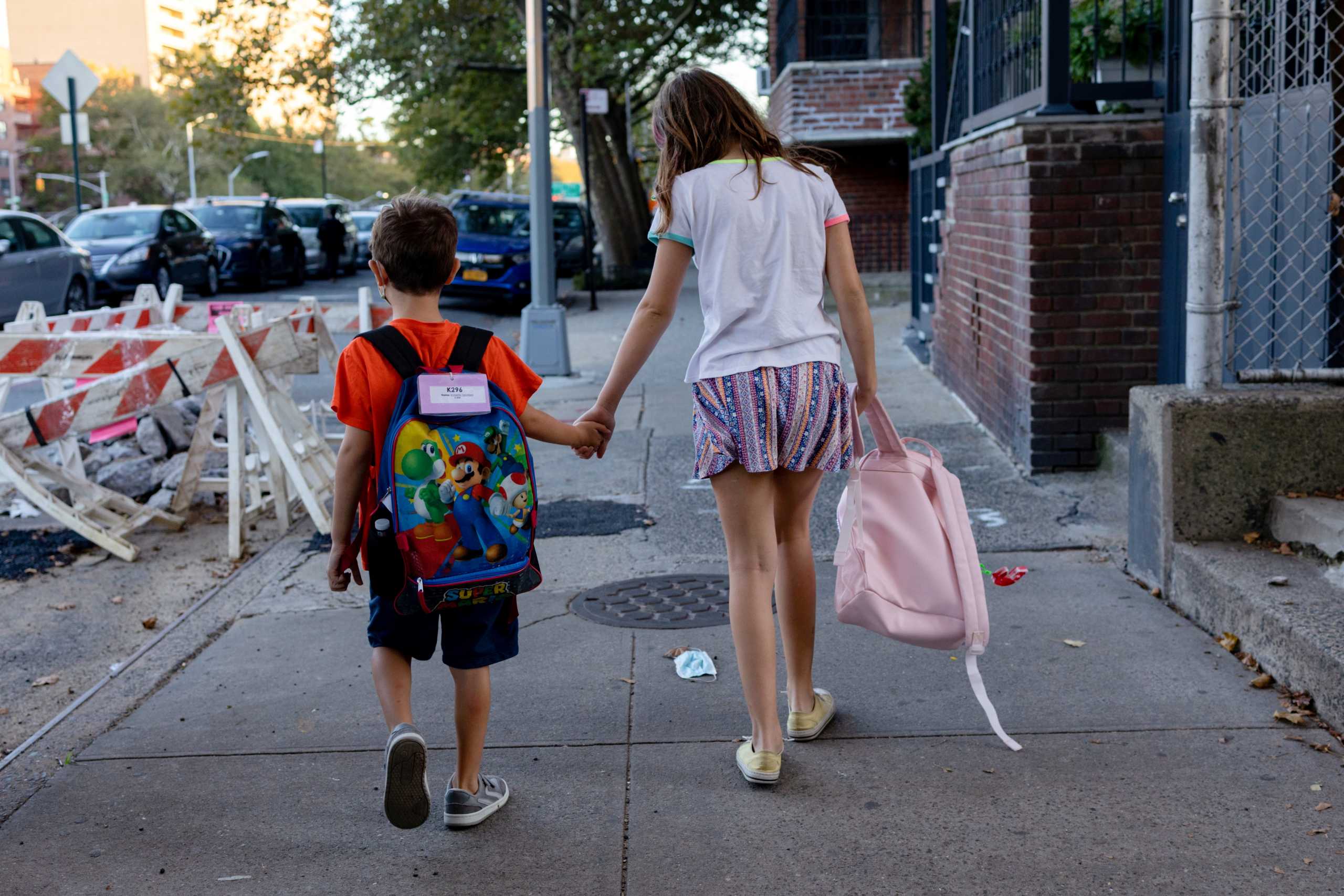 Special needs children, Roberto Tesoriero, 7, holds his sister Gianna Tesoriero's, 11, hand while walking home in Brooklyn, New York, U.S., September 20, 2021. Picture taken September 20, 2021. REUTERS