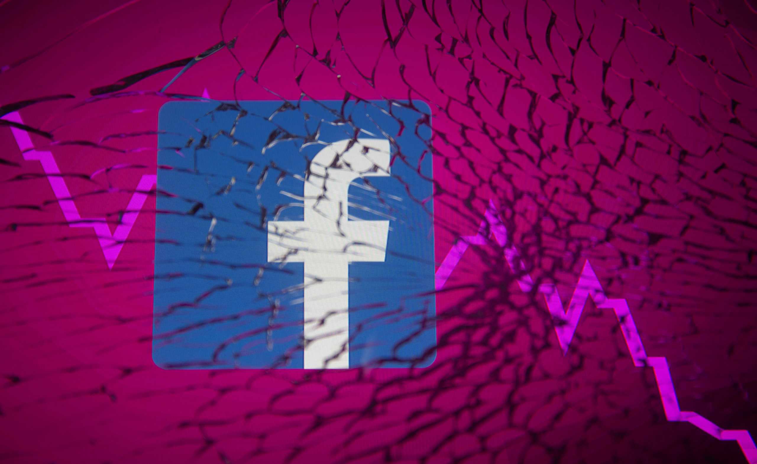 Facebook logo and stock graph are displayed through broken glass in this illustration taken October 4, 2021. REUTERS