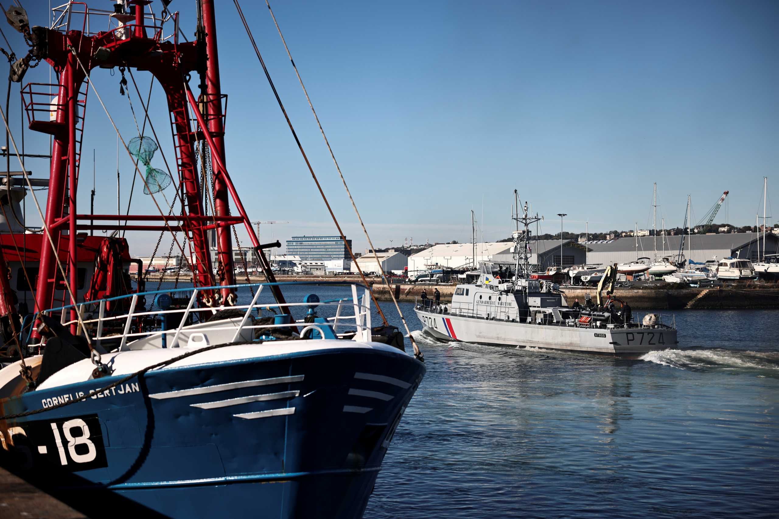 The French Gendarmerie patrol boat Athos leaves as a British trawler Cornelis Gert Jan is seen moored in the port of Le Havre after France seized on Thursday a British trawler fishing in its territorial waters without a licence, in Le Havre, France, October 28, 2021. REUTERS