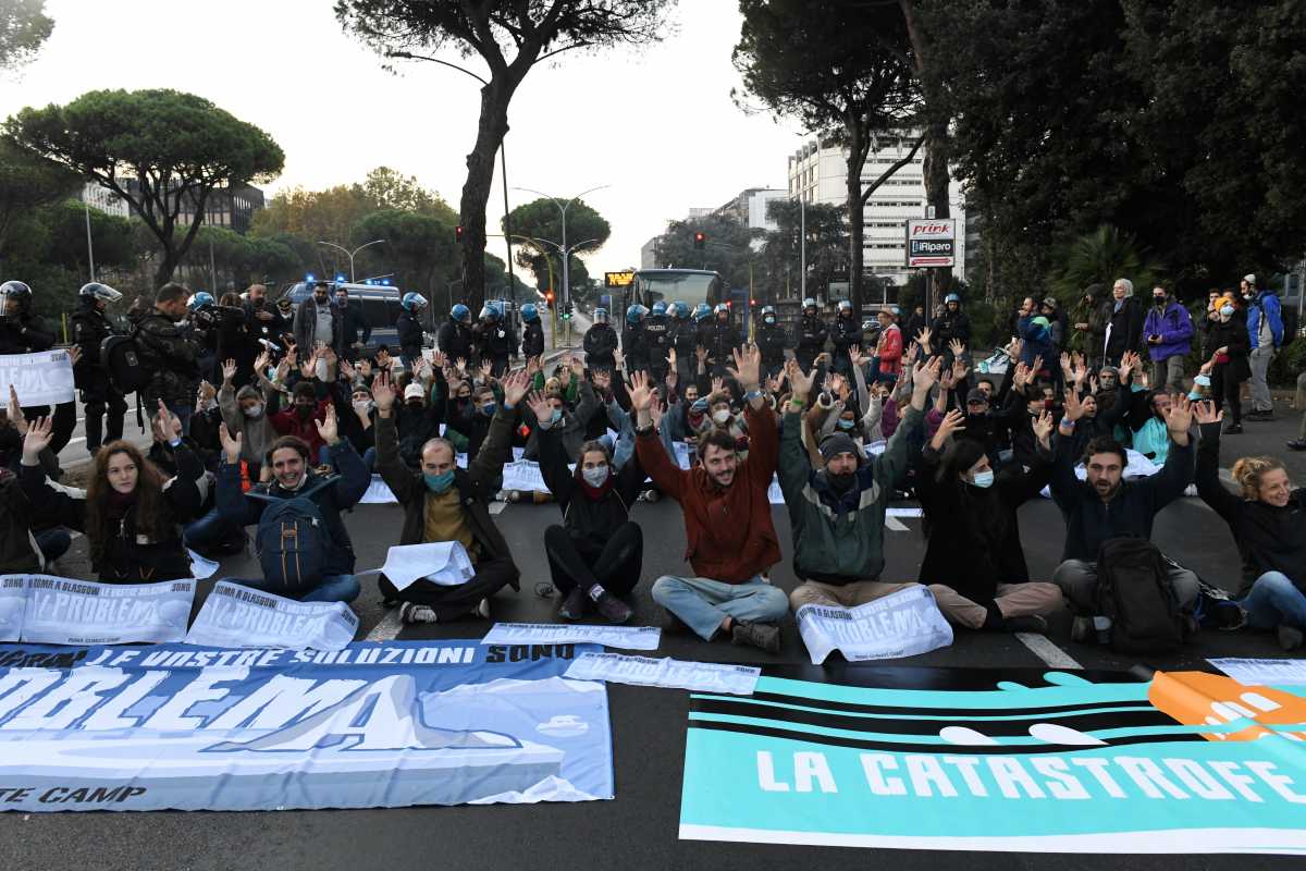 Extinction Rebellion activists raise their arms as they block a road near the Ministry of Ecological Transition during the G20 leaders summit in Rome, Italy, October 30, 2021. REUTERS