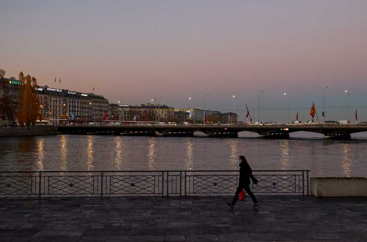 FILE PHOTO: A woman walks along Lake Leman banks during partial lockdown measures amid the coronavirus disease (COVID-19) outbreak in Geneva, Switzerland, November 18, 2020. REUTERS
