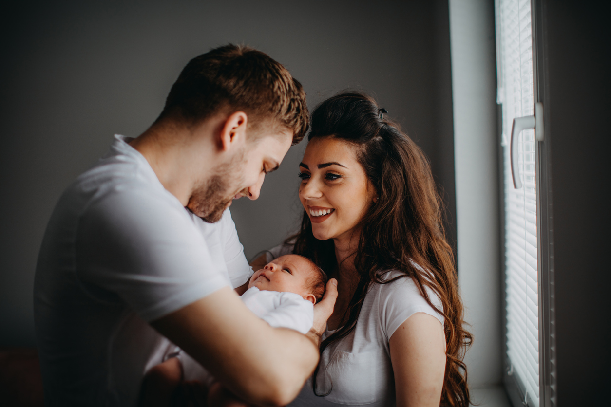 Happy parents playing with their newborn daughter