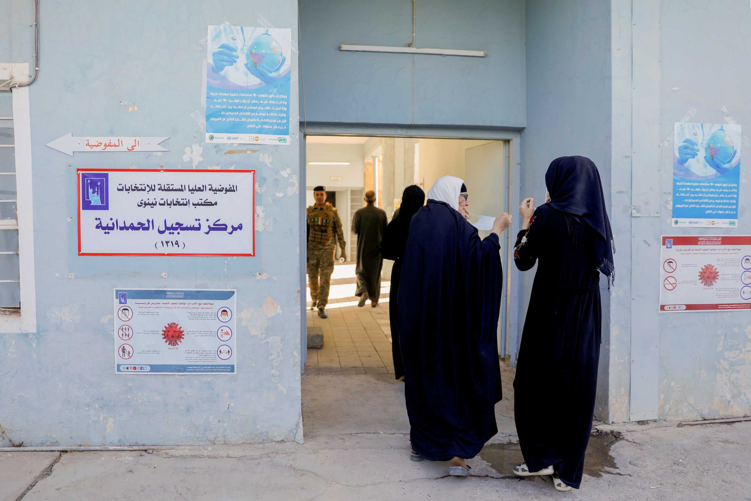 Women walk into a polling station during the parliamentary election, in Qaraqosh, Iraq, October 10, 2021. REUTERS