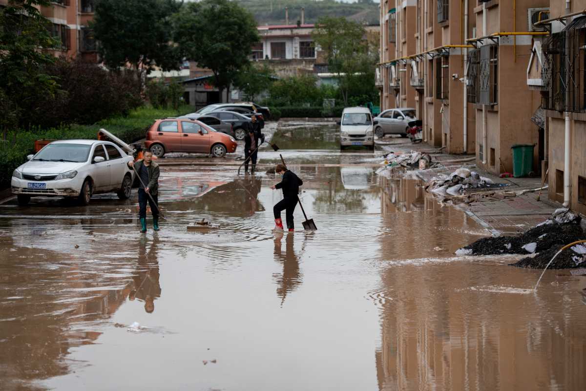 Villagers clear floodwaters near residential houses following heavy rainfall in Yitang county, Jiexiu city, Shanxi province, China October 10, 2021. Picture taken October 10, 2021. cnsphoto via REUTERS ATTENTION EDITORS - THIS IMAGE WAS PROVIDED BY A THIRD PARTY. CHINA OUT.