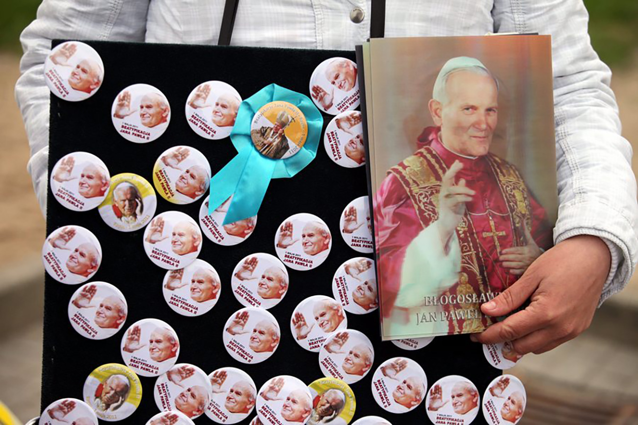 epa02712233 A "mobile vendor" moves through the crowds in Pilsudski's Square in Warsaw, Poland 1 May 2011 to sell button badges of the late Polish-born Pope John Paul II on the occasion of his beatification which took places in St. Peter's Square, Vatican during the day.  EPA