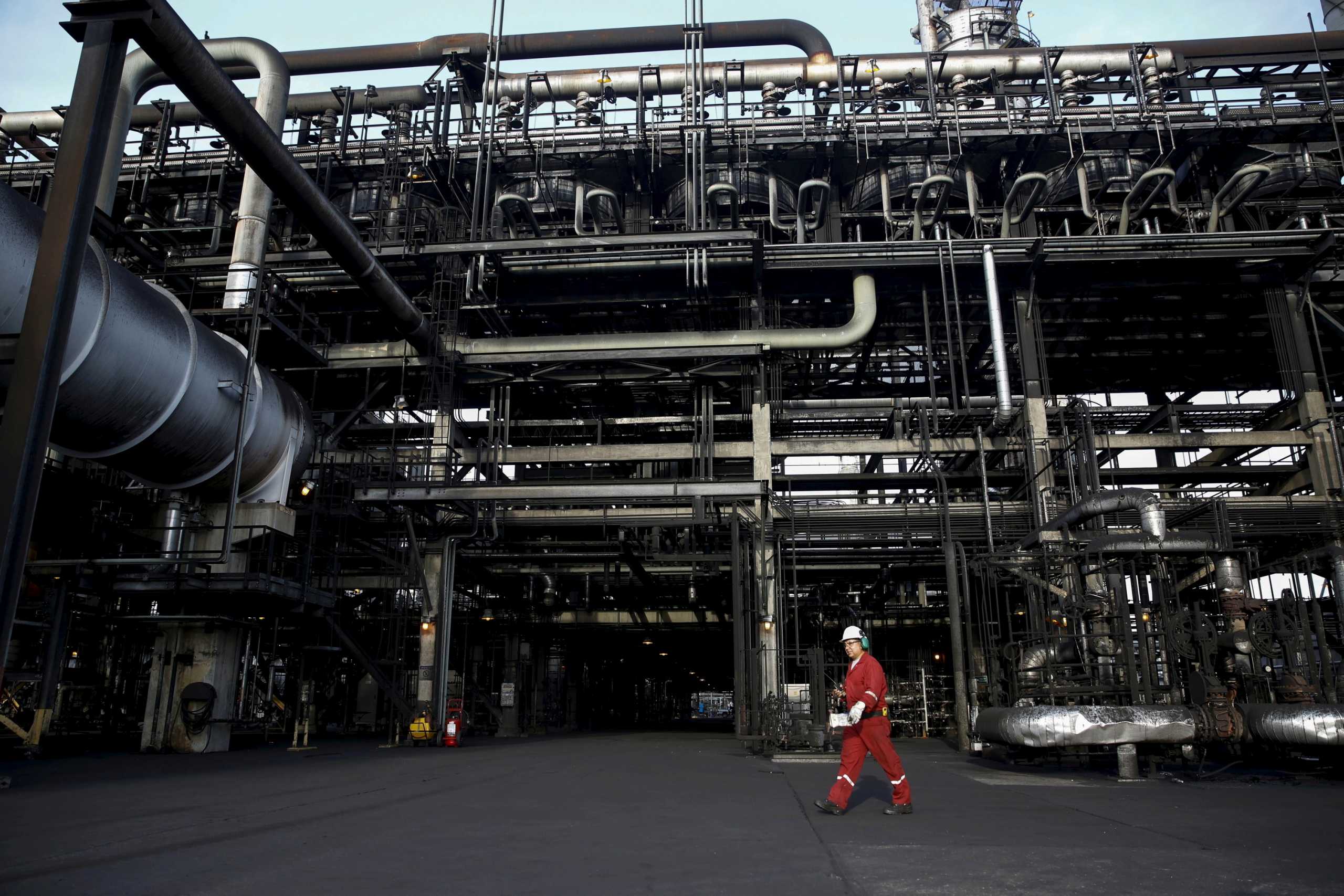 FILE PHOTO: An oilfield worker walks next to pipelines at PDVSA's Jose Antonio Anzoategui industrial complex in the state of Anzoategui April 15, 2015. REUTERS