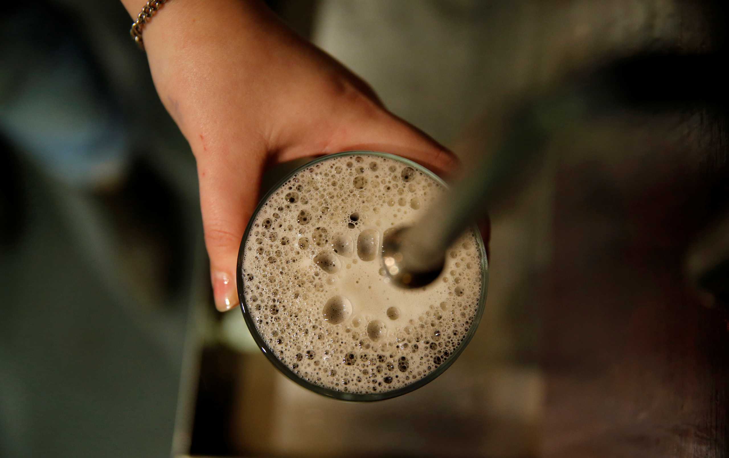 FILE PHOTO: A bartender pulls a pint of bitter at the Flying Horse pub in London November 19, 2014. REUTERS