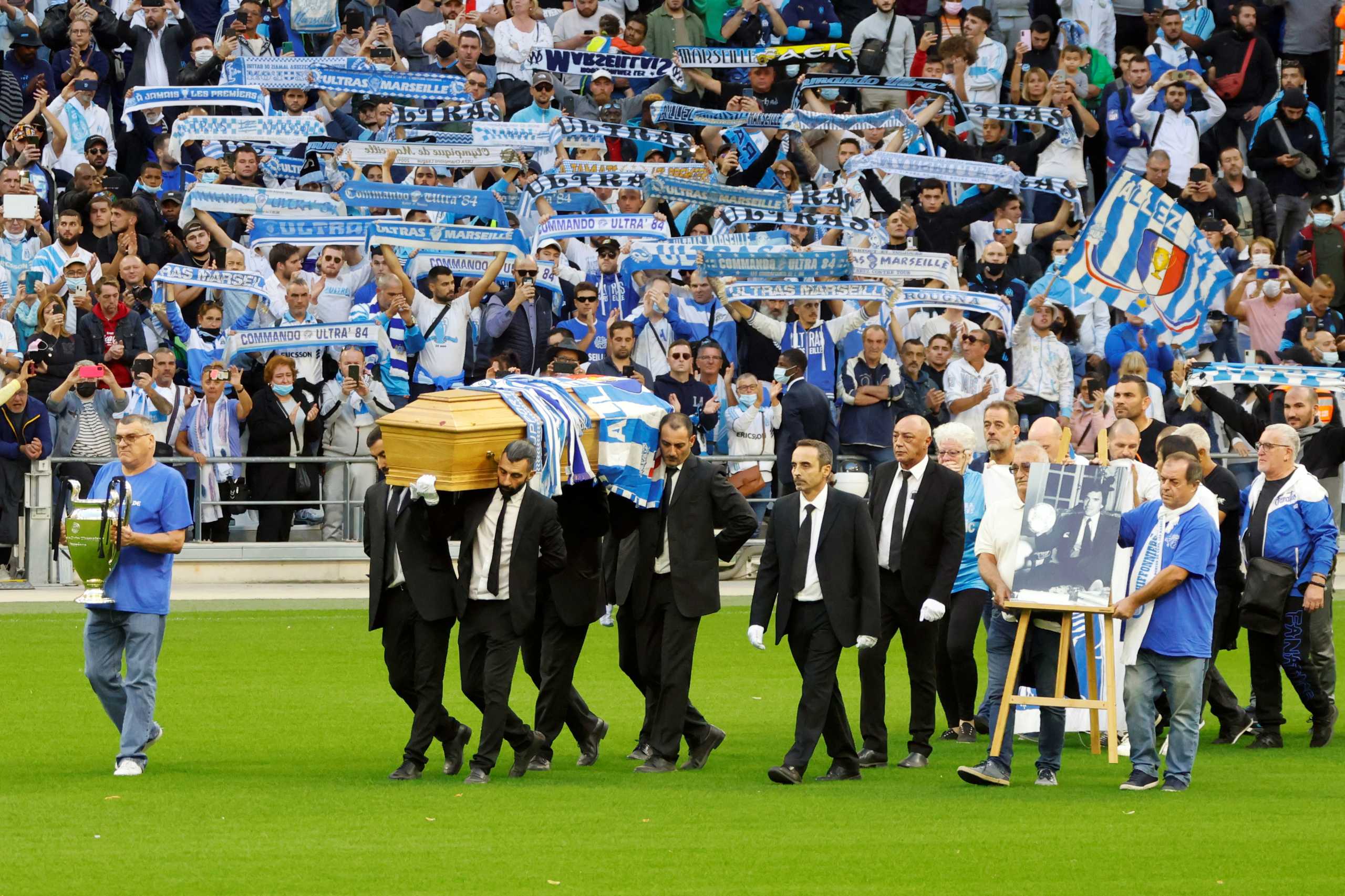 Pallbearers carry the coffin of later Bernard Tapie, French businessman and former Olympique de Marseille chairman, on the pitch during a ceremony at the Velodrome Stadium in Marseille, France, October 7, 2021. REUTERS
