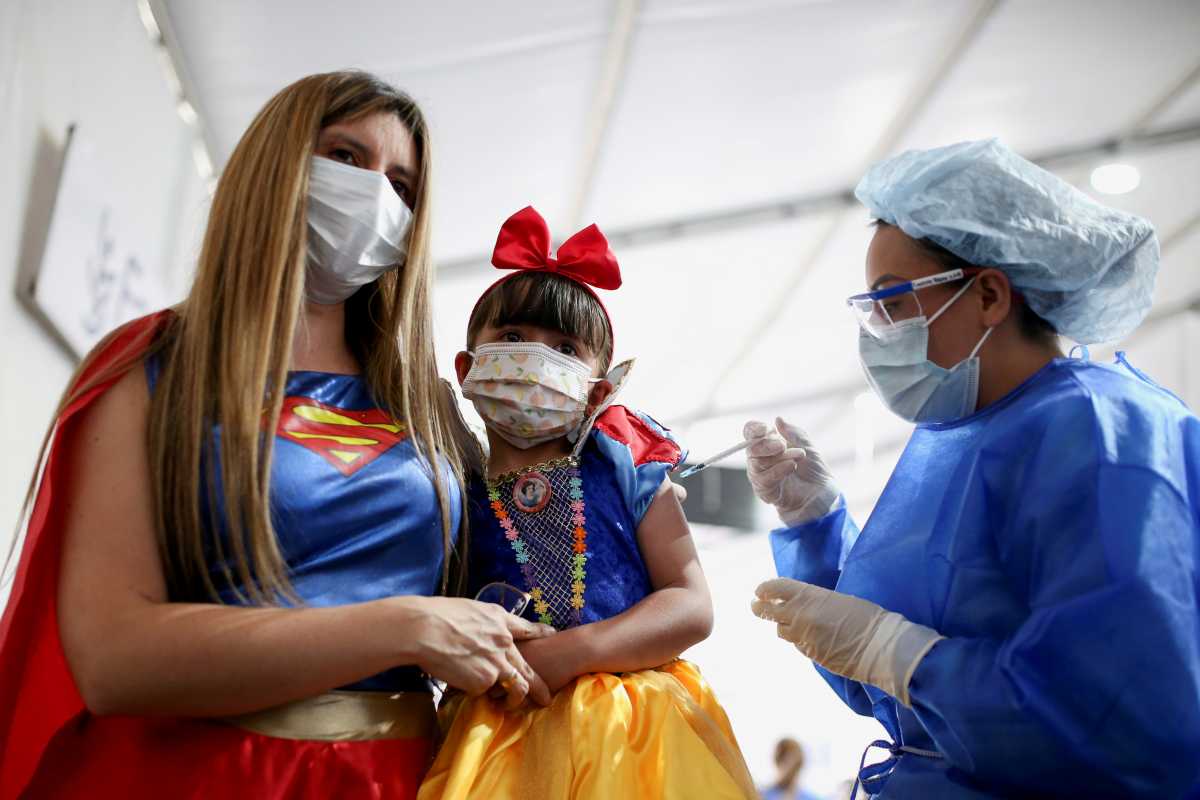 A woman dressed as Wonder Woman hugs her daughter dressed as Snow White while she receives her first dose of China's SINOVAC vaccine against the coronavirus disease (COVID-19) as the Colombian government begins a vaccination campaign for kids, in Bogota, Colombia October 31, 2021. REUTERS