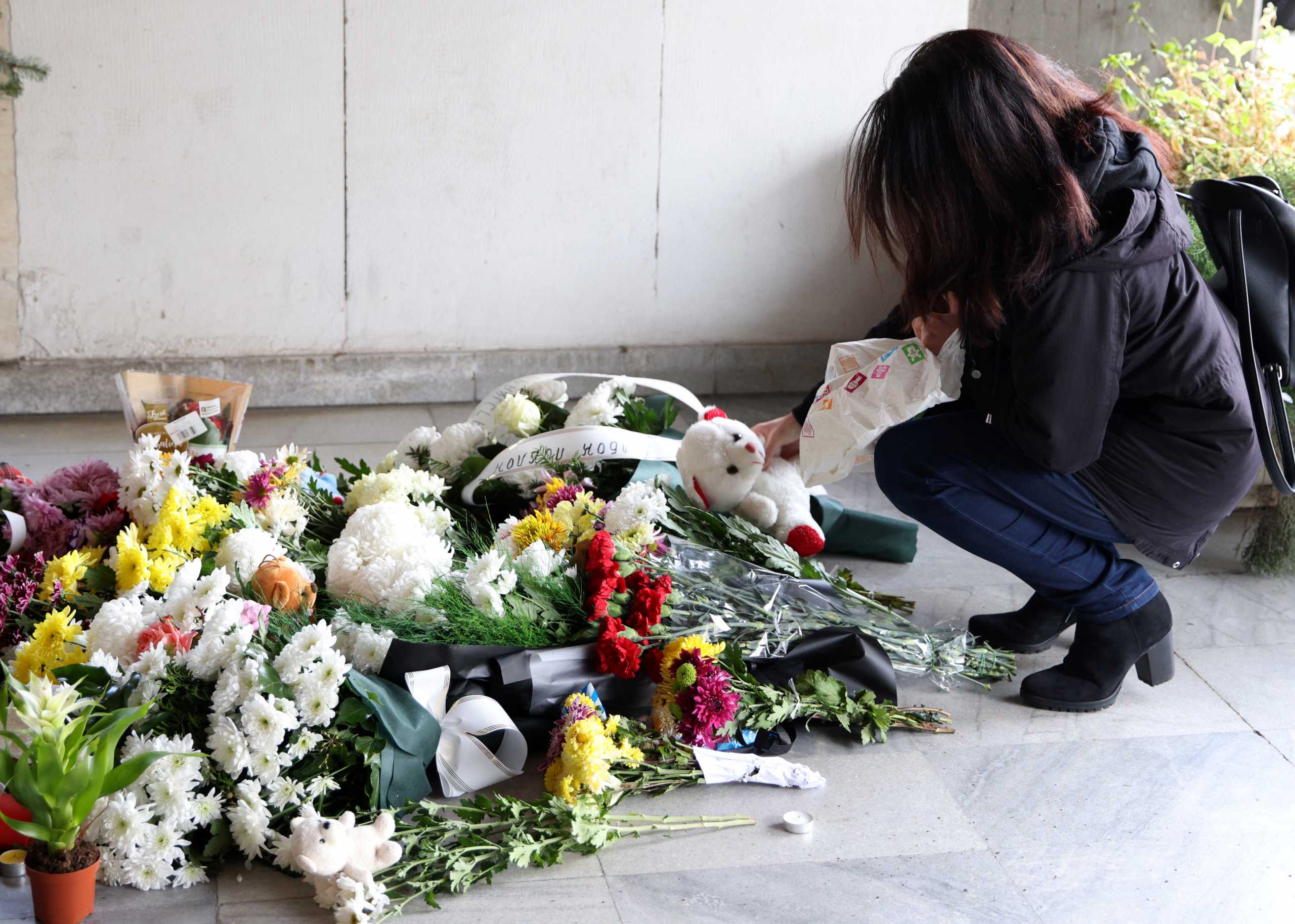 A woman places a teddy bear at a makeshift memorial for the victims of Tuesday's bus accident, in front of the embassy of North Macedonia, Sofia, Bulgaria, November 24, 2021. REUTERS