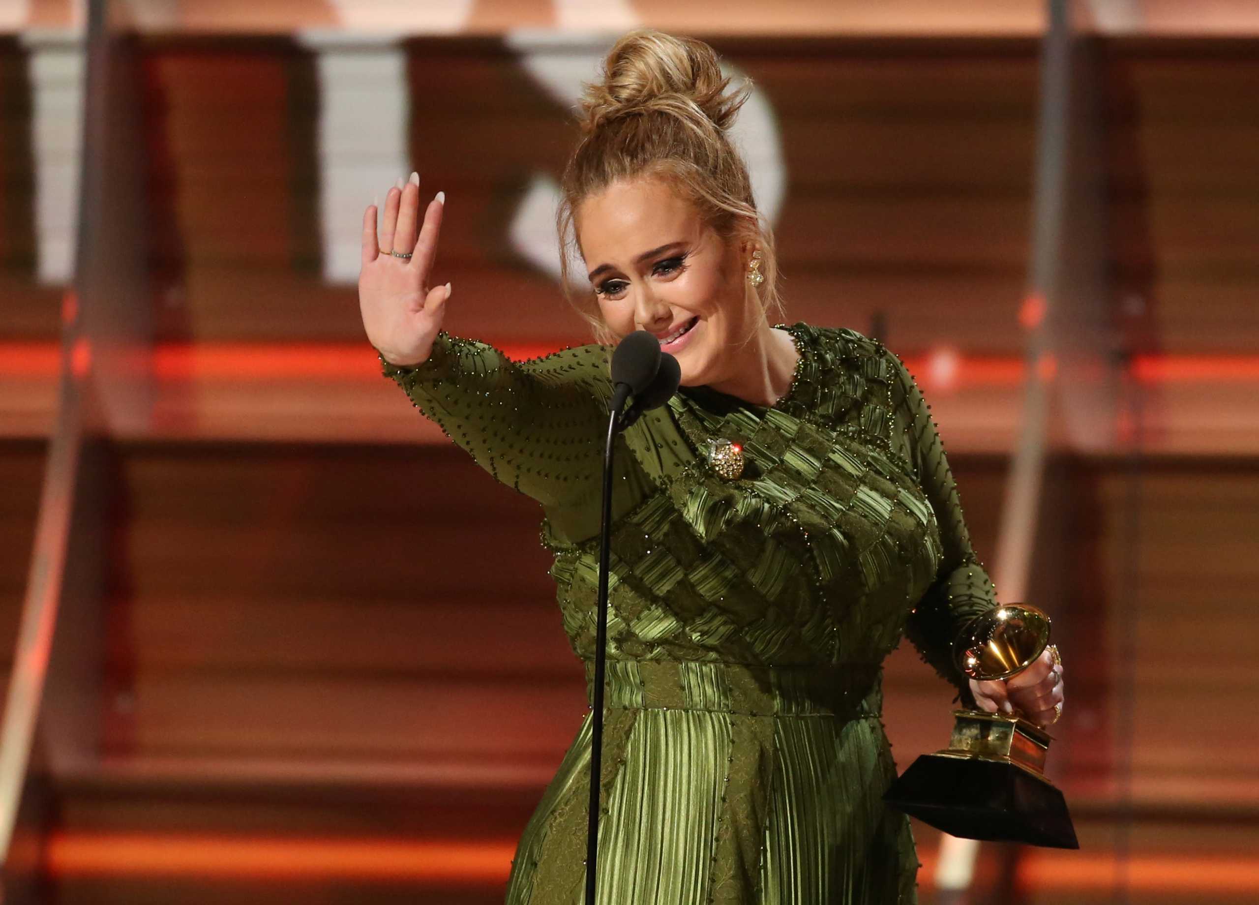 FILE PHOTO: Adele waves to singer Beyonce who is in the audience as she and co-song writer Greg Kurstin (not pictured) accept the Grammy for Song of the Year for "Hello" at the 59th Annual Grammy Awards in Los Angeles, California, U.S. , February 12, 2017. REUTERS