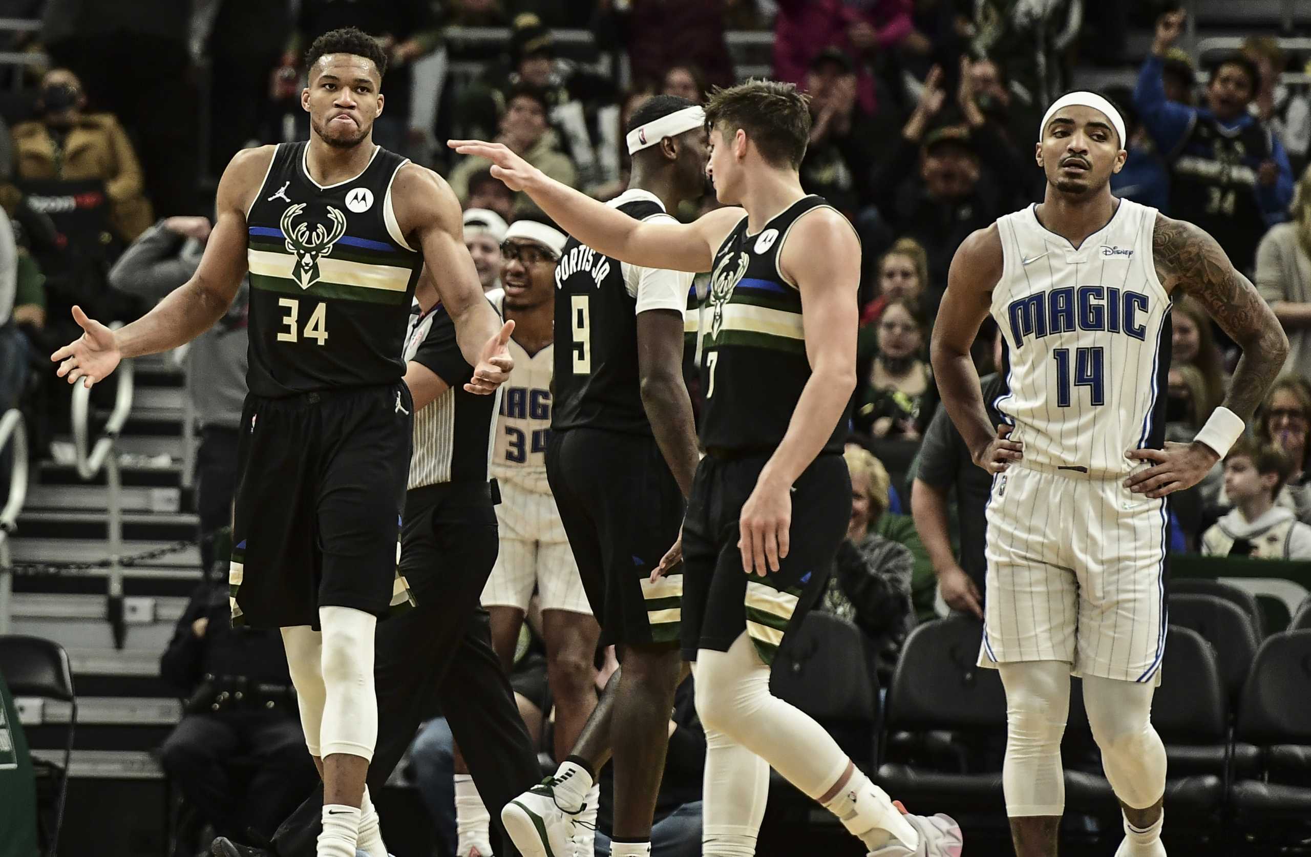 Nov 20, 2021; Milwaukee, Wisconsin, USA;  Milwaukee Bucks forward Giannis Antetokounmpo (34) celebrates with guard Grayson Allen (7) after scoring a basket in the third quarter as Orlando Magic guard Gary Harris (14) looks on at Fiserv Forum. Mandatory Credit: Benny Sieu-USA TODAY Sports