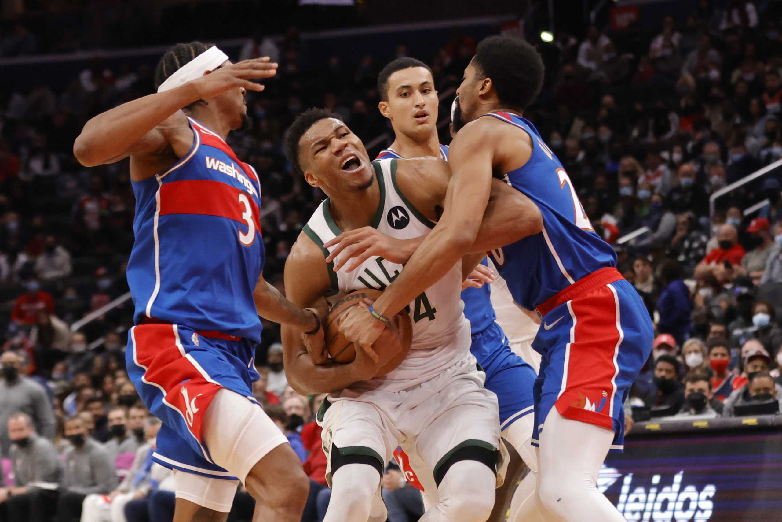 Nov 7, 2021; Washington, District of Columbia, USA; Milwaukee Bucks forward Giannis Antetokounmpo (34) is fouled while driving to the basket by Washington Wizards guard Spencer Dinwiddie (26) during the fourth quarter at Capital One Arena. Mandatory Credit: Geoff Burke-USA TODAY Sports