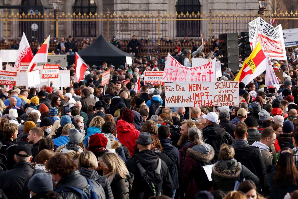 Demonstrators hold flags and placards as they gather to protest against the coronavirus disease (COVID-19) measures in Vienna, Austria, November 20, 2021. The placard reads: "For the truth, no to mandatory vaccination, protect our rights." REUTERS