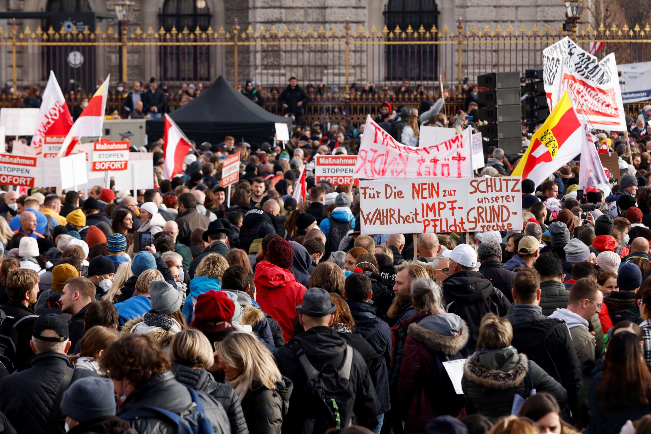 Demonstrators hold flags and placards as they gather to protest against the coronavirus disease (COVID-19) measures in Vienna, Austria, November 20, 2021. The placard reads: "For the truth, no to mandatory vaccination, protect our rights." REUTERS