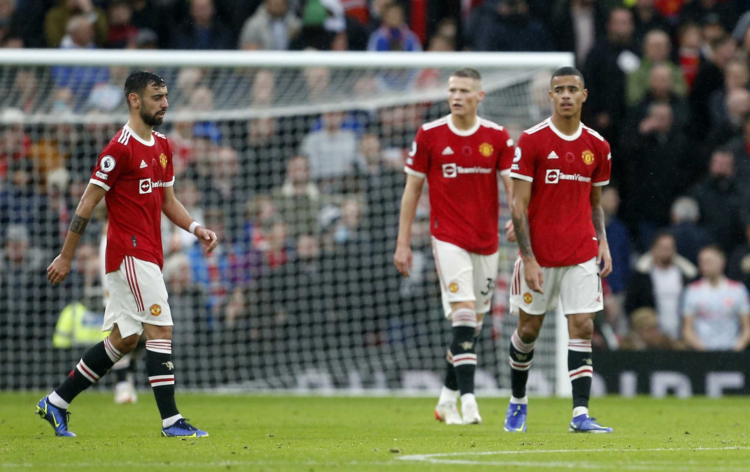 Soccer Football - Premier League - Manchester United v Manchester City - Old Trafford, Manchester, Britain - November 6, 2021 Manchester United's Bruno Fernandes , Scott McTominay and Mason Greenwood look dejected after Manchester City's Bernardo Silva scores their second goal REUTERS