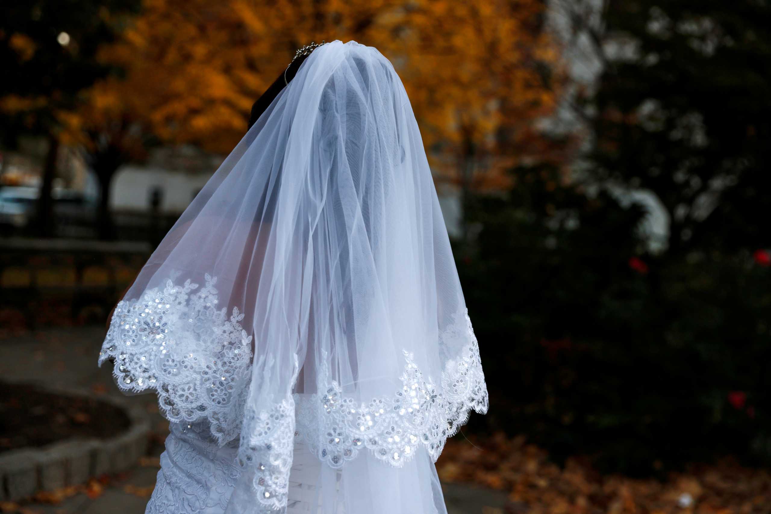 A bride stands in a park across the street from the Manhattan Marriage Bureau in New York City, New York, U.S., November 18, 2021. REUTERS