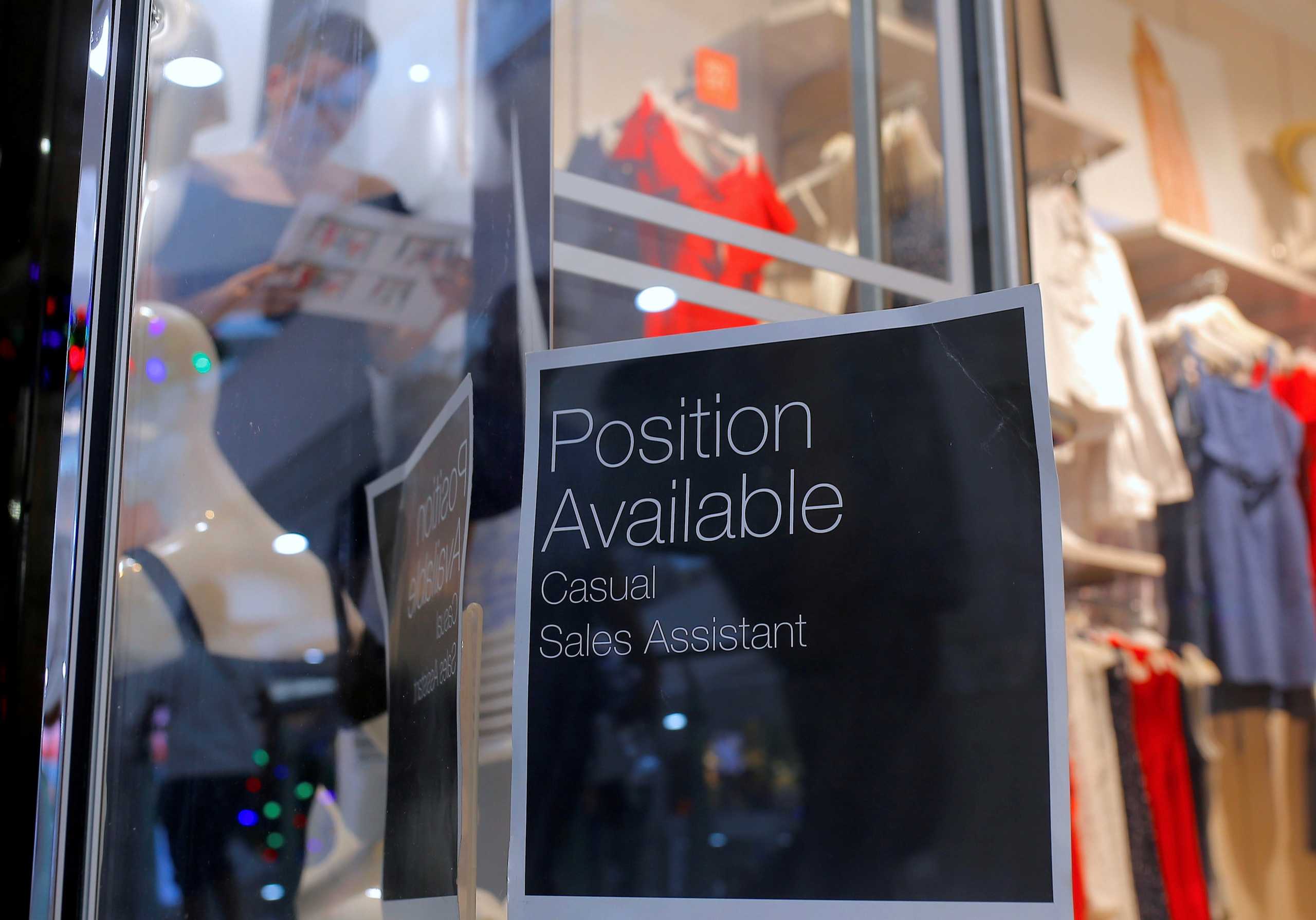 FILE PHOTO: A sales assistant is seen through the window of a retail store displaying a job vacancy sign in central Sydney, Australia, December 5, 2016. Picture taken December 5, 2016.     REUTERS