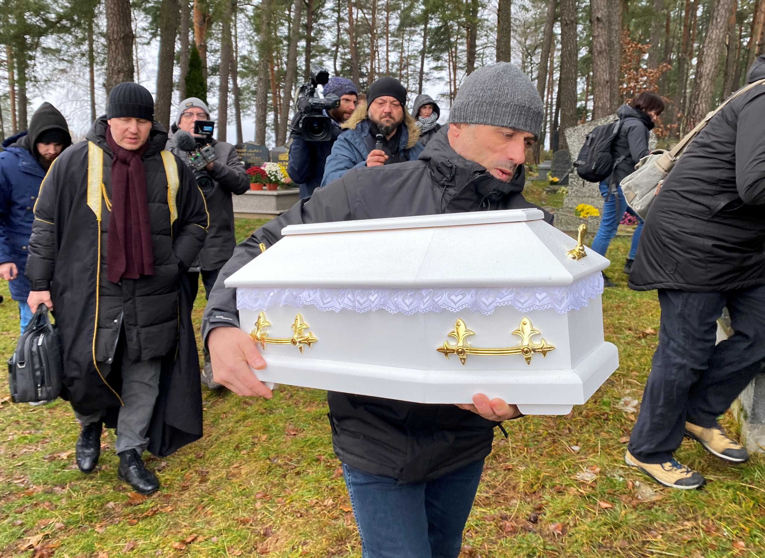A member of the Polish Muslim community carries a coffin during a funeral of an unborn child Halikari Dhaker, who died in the womb of his mother during the migrant crisis at the Belarusian-Polish border, at a cemetery in the village of Bohoniki near Sokolka, Poland November 23, 2021. REUTERS