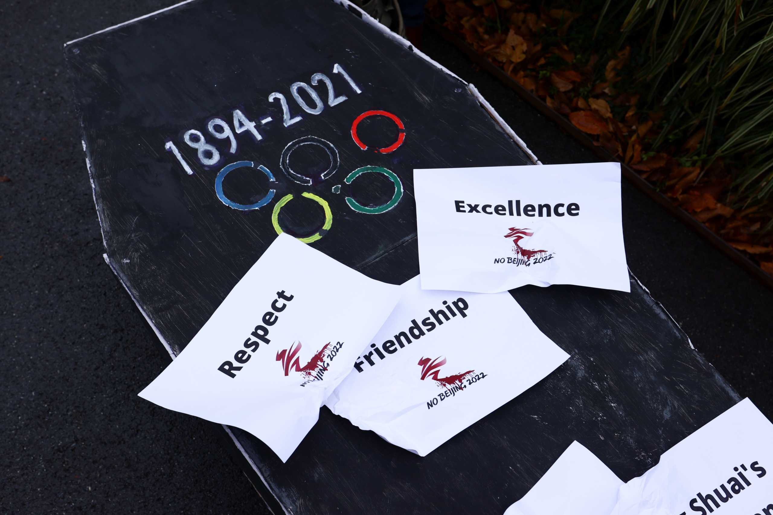A coffin is displayed as protesters take part in a mock funeral outside the International Olympic Committee (IOC) headquarters as part of the No Beijing 2022 campaign, a coalition of over 180 rights groups that are calling for a boycott of Beijing 2022, in Lausanne, Switzerland November 26, 2021. REUTERS