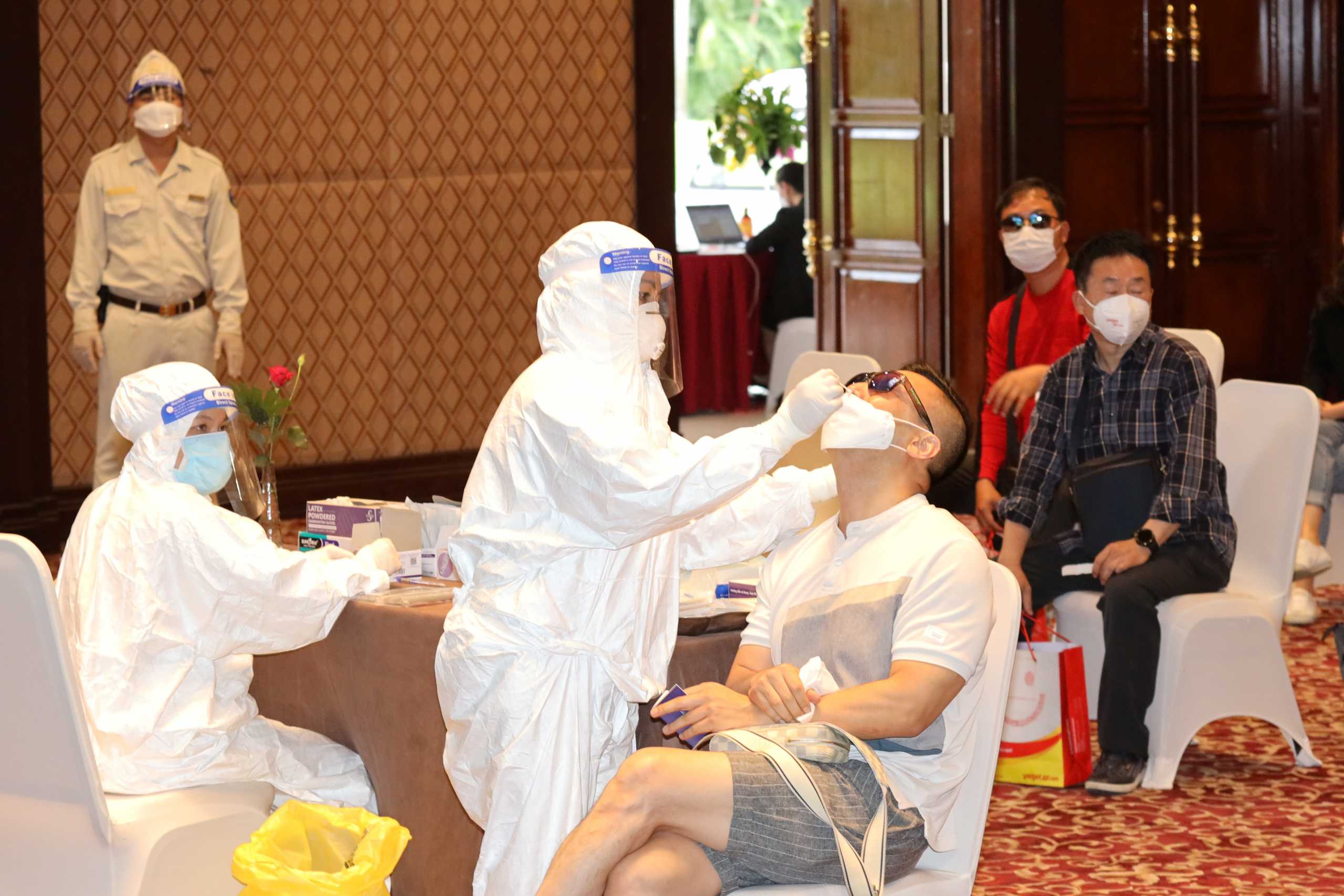 A healthcare worker takes a nasal swab sample from a South Korean tourist for a coronavirus disease (COVID-19) test upon their arrival in Phu Quoc island, among the first wave of visitors in nearly two years as the country seeks to resurrect its pandemic-ravaged tourism economy, in Vietnam, November 20, 2021. VINPEARL