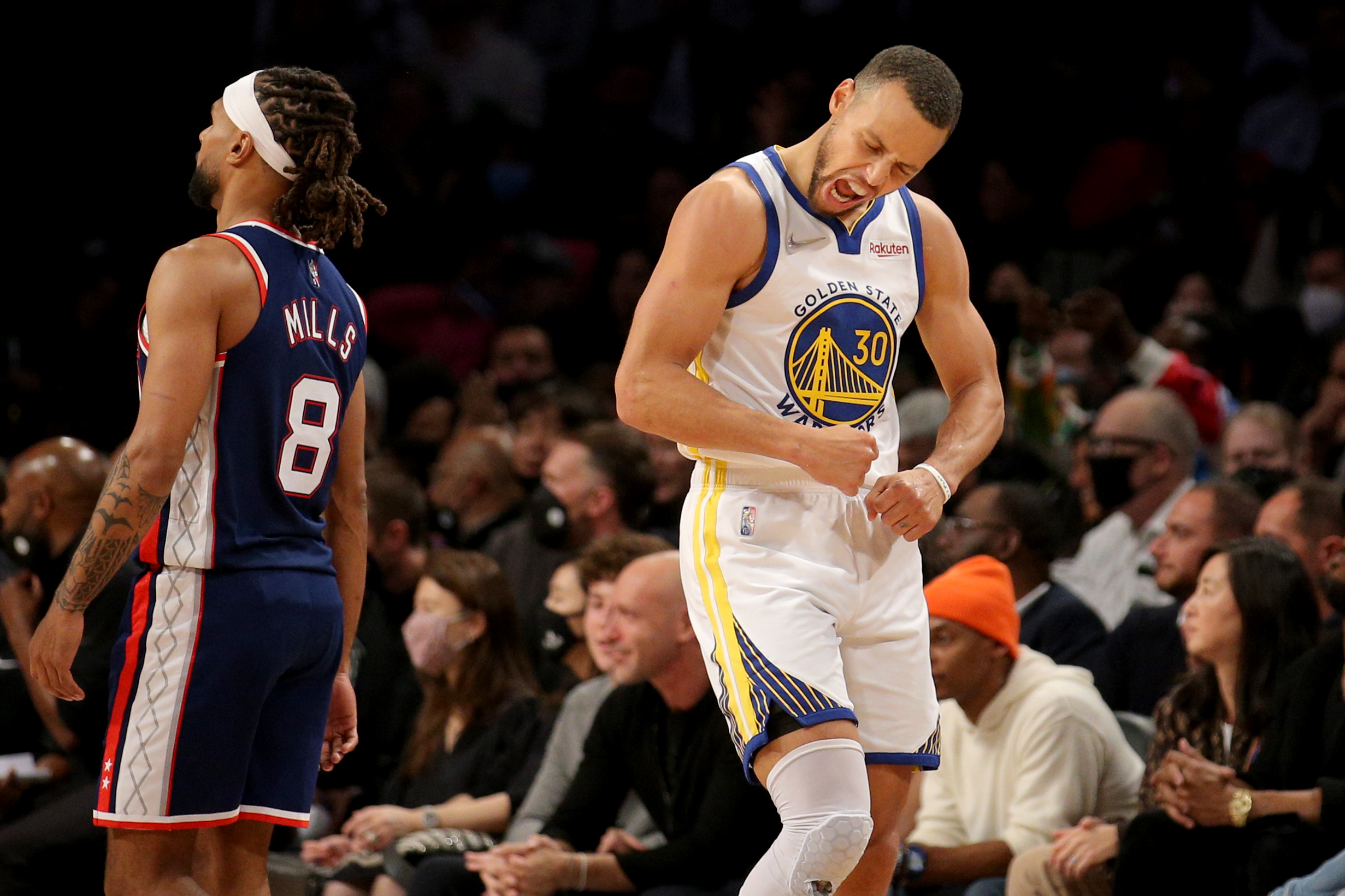 Nov 16, 2021; Brooklyn, New York, USA; Golden State Warriors guard Stephen Curry (30) reacts in front of Brooklyn Nets guard Patty Mills (8) during the fourth quarter at Barclays Center. Mandatory Credit: Brad Penner-USA TODAY Sports
