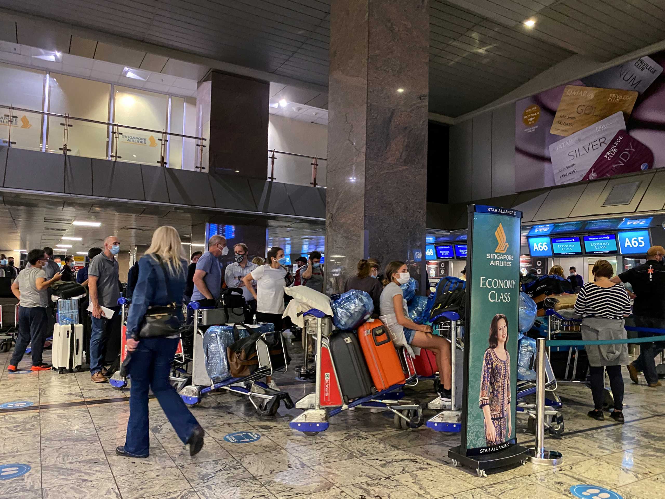Passengers queue to check in for a flight on Singapore Airlines at O.R. Tambo International Airport in Johannesburg, South Africa, November 26, 2021. REUTERS