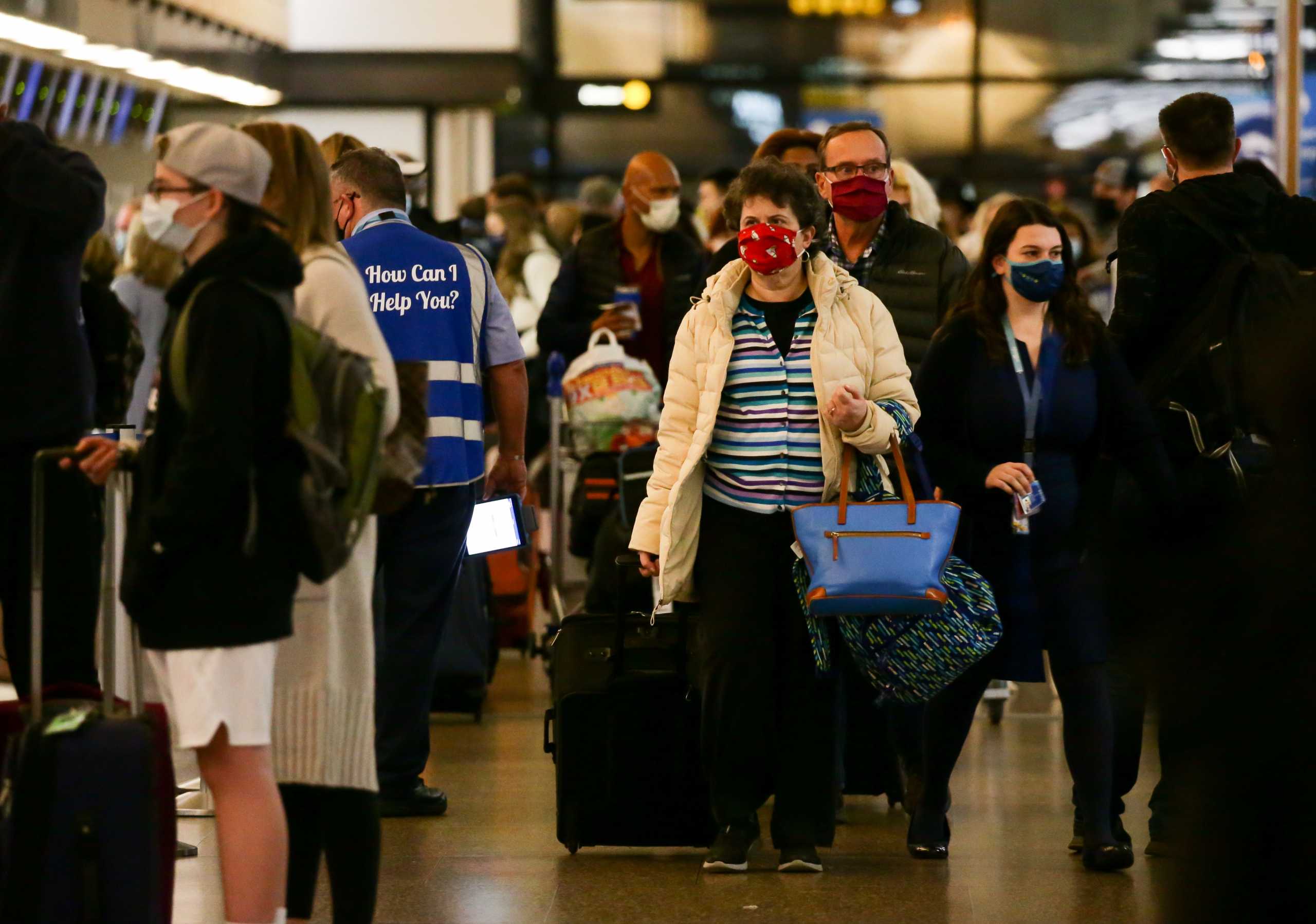 A traveler carries bags as people arrive at the ticketing level at Seattle-Tacoma International Airport before the Thanksgiving holiday in Seattle, Washington, U.S. November 24, 2021.  REUTERS