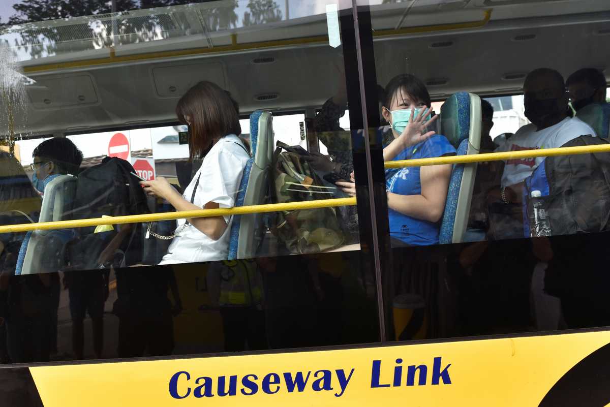 People leaving on a bus back to Malaysia as the Vaccinated Travel Lane between Singapore and Malaysia opens after the land border between the two countries reopened following nearly two years of being shut down due to the coronavirus disease (COVID-19) pandemic, at a bus station in Singapore November 29, 2021. REUTERS