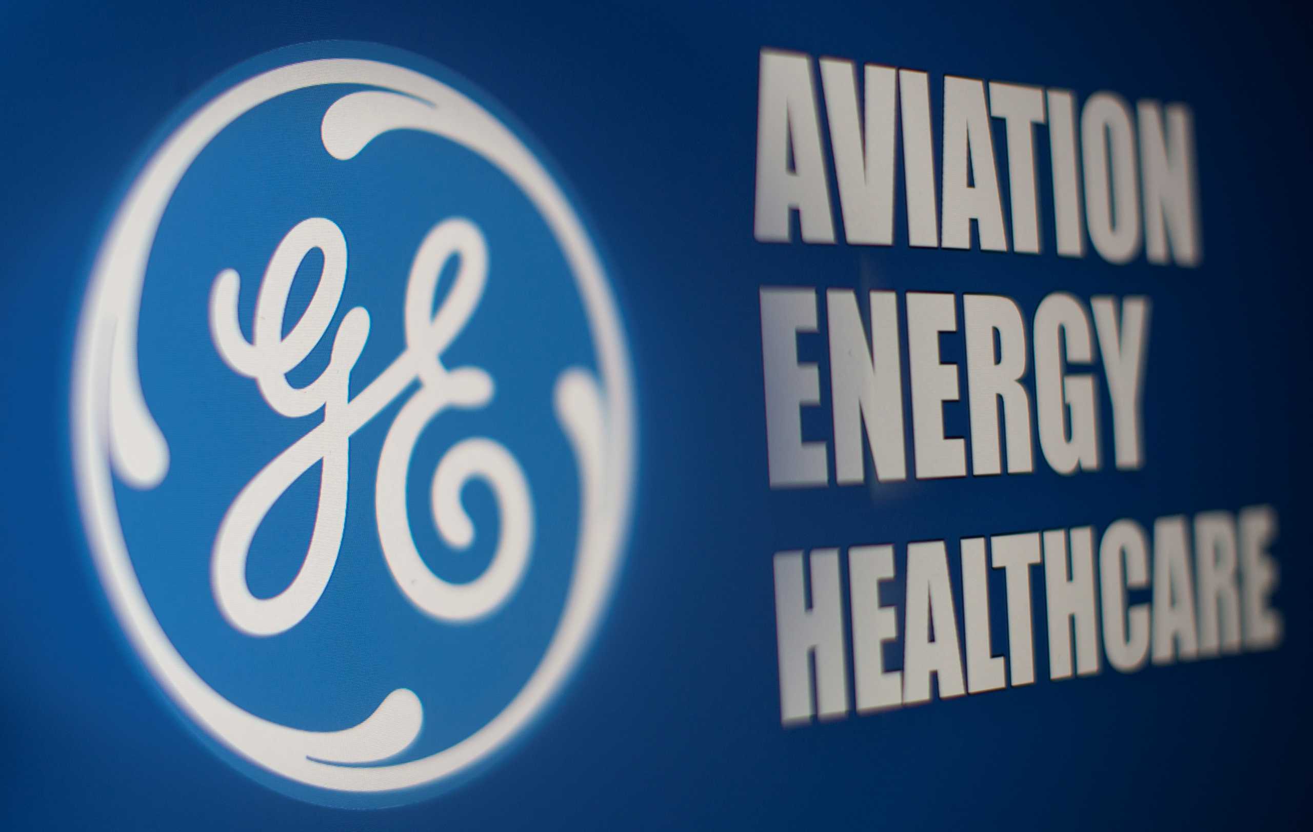 General Electric logo is seen through magnifier in front of displayed Aviation, Energy, Healthcare words in this illustration taken, November 9, 2021. REUTERS