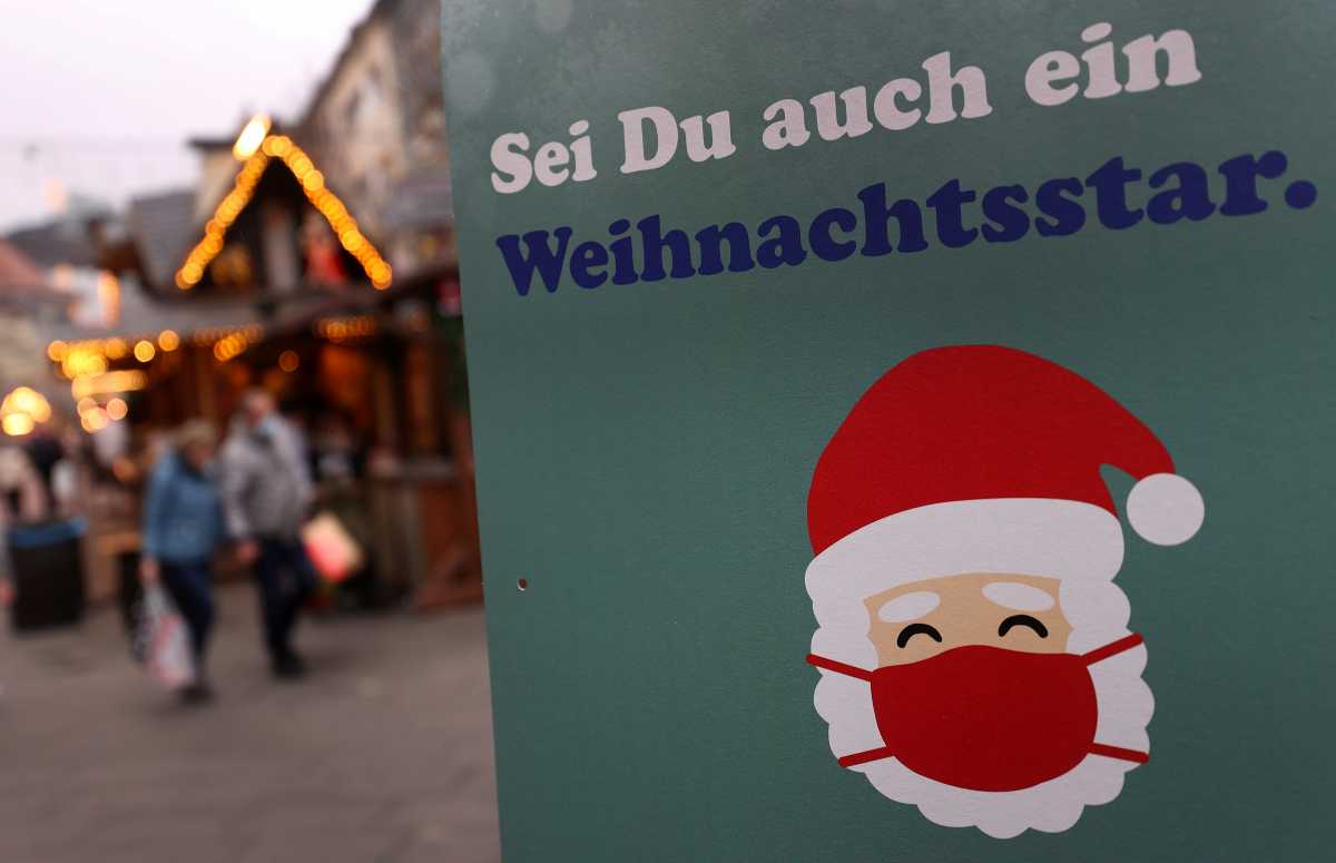 A placard reading "Be a Christmas star" encourages visitors to wear a protective mask as the spread of the coronavirus disease (COVID-19) continues, at the Christmas market in Giessen, Germany, November 19, 2021.  REUTERS