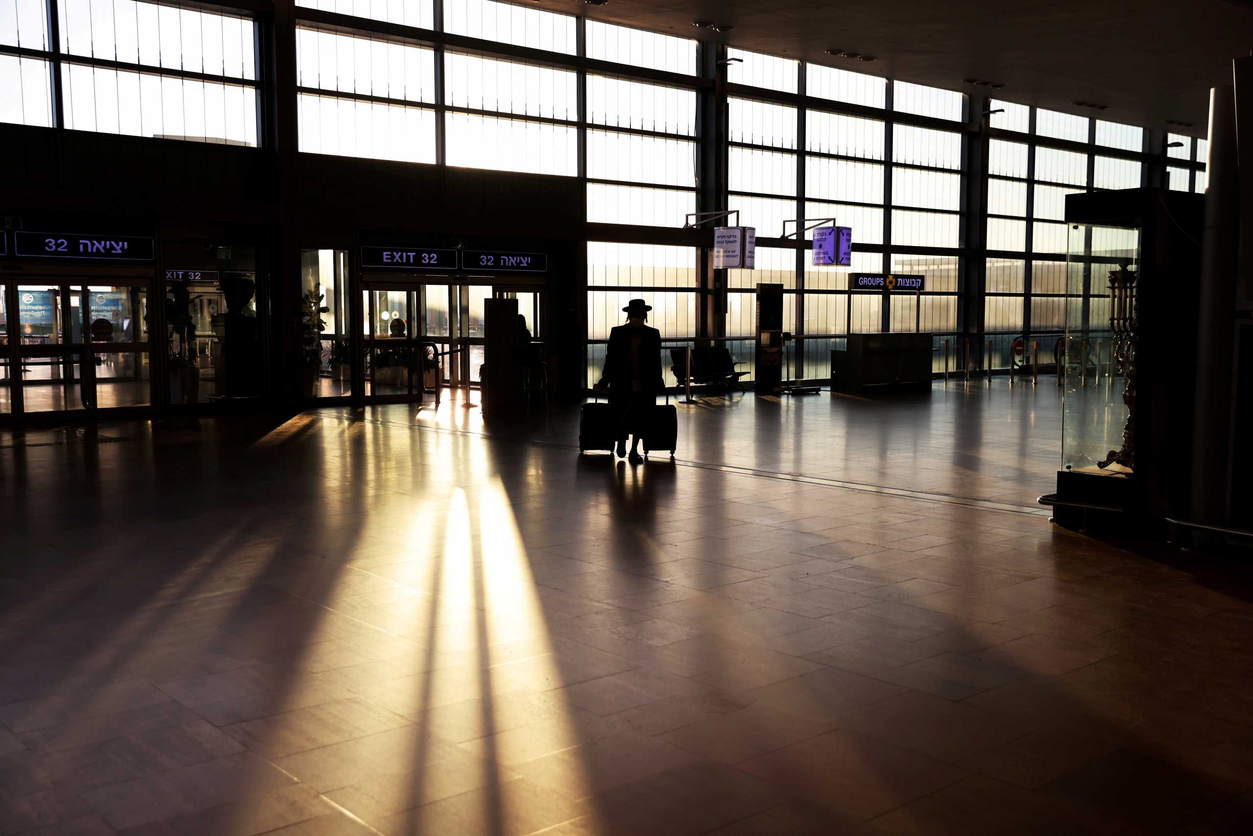 FILE PHOTO: A passenger arrives to a terminal at Ben Gurion international airport before Israel bans international flights, taking effect from Monday, Jan. 25,  midnight, until the end of January, in order to stop the spread of the coronavirus disease (COVID-19) and new coronavirus strains, in Lod near Tel Aviv, Israel January 25, 2021. REUTERS