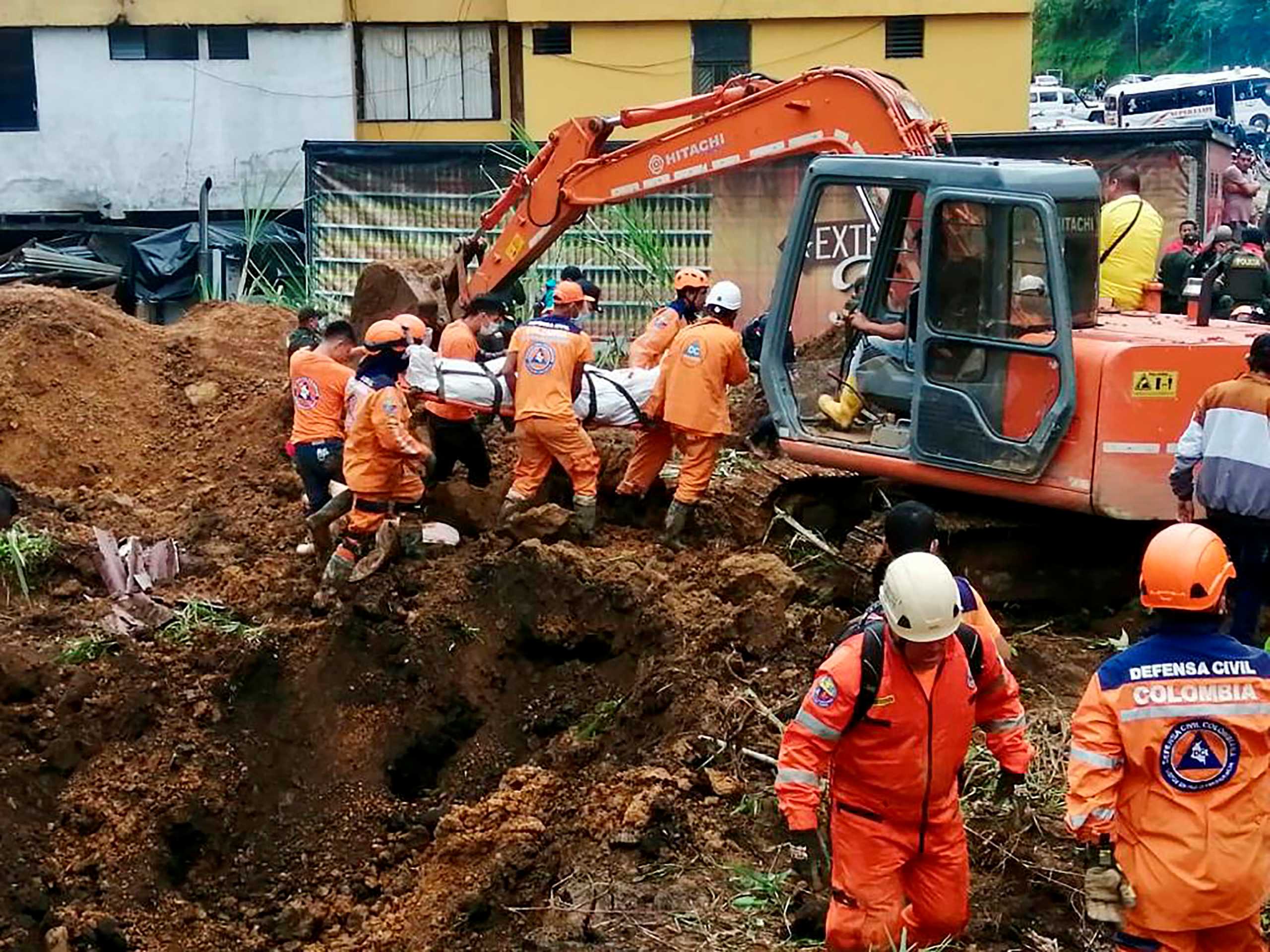 Colombian Civil Defense workers unearth the body of a deceased person in a landslide that was caused by heavy rains in the country, in Mallana, Colombia November 2, 2021. Colombian Civil Defense