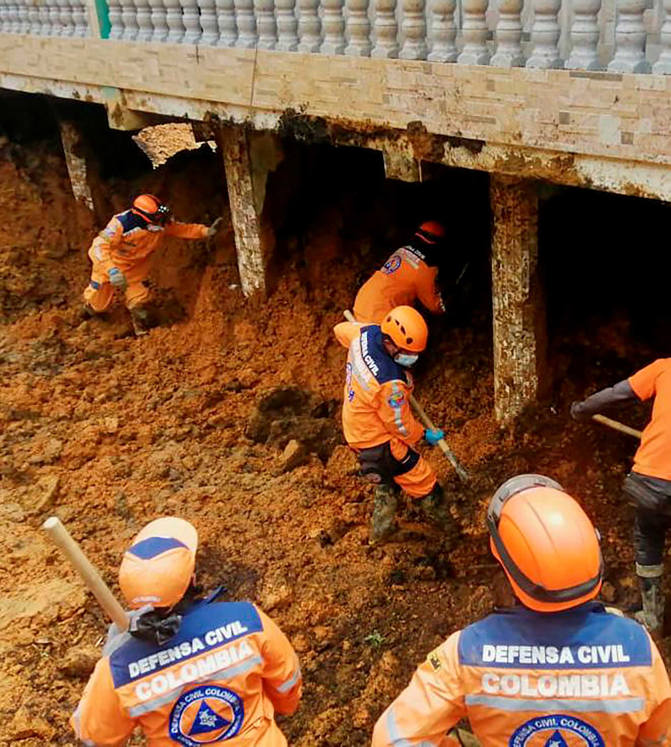 Colombian Civil Defense workers excavate a landslide that was caused by heavy rains in the country, in Mallana, Colombia November 2, 2021. Colombian Civil Defense