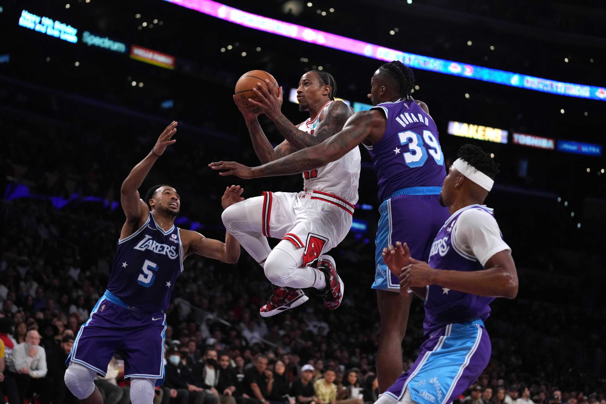 Nov 15, 2021; Los Angeles, California, USA; Chicago Bulls forward DeMar DeRozan (11) is defended by Los Angeles Lakers guard Talen Horton-Tucker (5) and center Dwight Howard (39)  in the second half at Staples Center. The Bulls defeated the Lakers 121-103.  Mandatory Credit: Kirby Lee-USA TODAY Sports