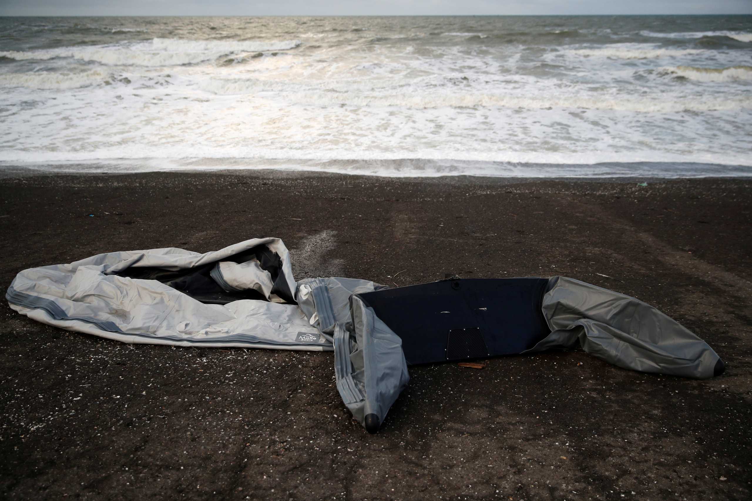 A damaged inflatable dinghy is seen on Loon Beach, the day after 27 migrants died when their dinghy deflated as they attempted to cross the English Channel, in Dunkerque near Calais, France, November 25, 2021. REUTERS