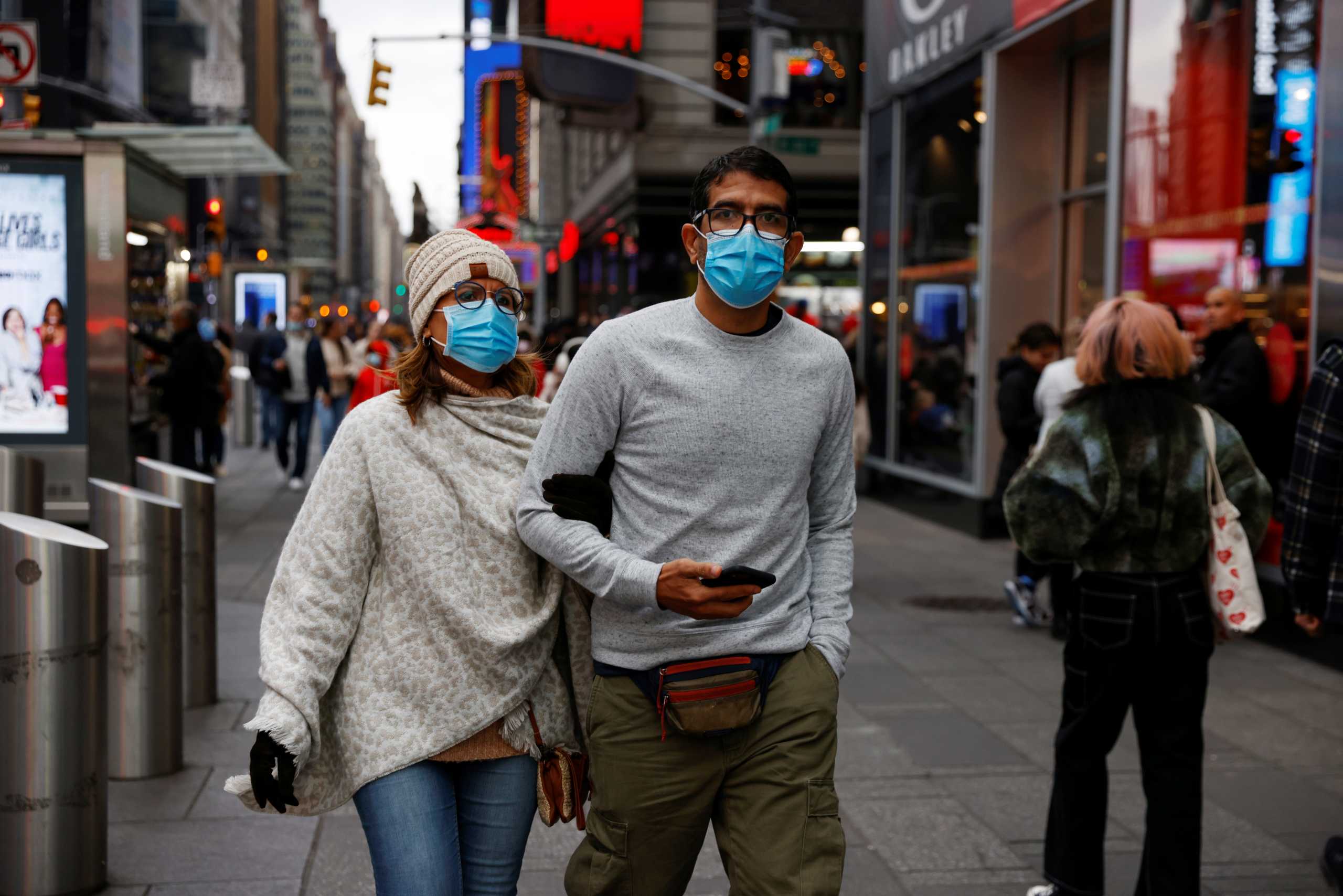 People wearing protective face masks, amid the coronavirus disease (COVID-19) pandemic, walk through Times Square in New York City, U.S., November 22, 2021.  REUTERS