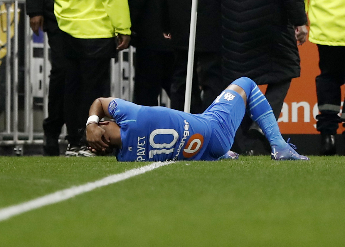 Soccer Football - Ligue 1 - Olympique Lyonnais v Olympique de Marseille - Groupama Stadium, Lyon, France - November 21, 2021  Olympique de Marseille's Dimitri Payet goes down after being hit by a water bottle thrown by a fan leading to the game being interrupted REUTERS