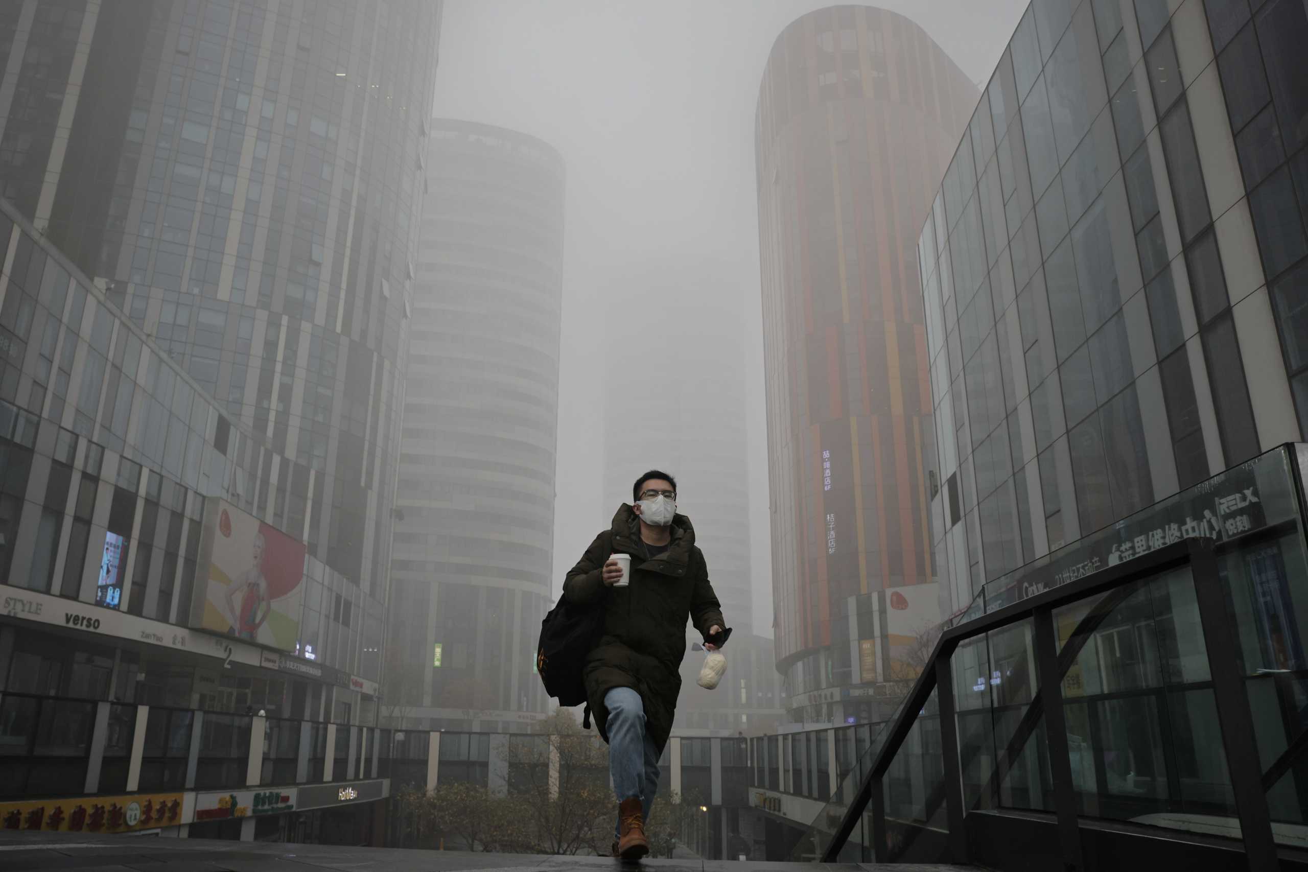 A man walks in the Sanlitun shopping district on a polluted day, in Beijing, China, November 6, 2021.  REUTERS