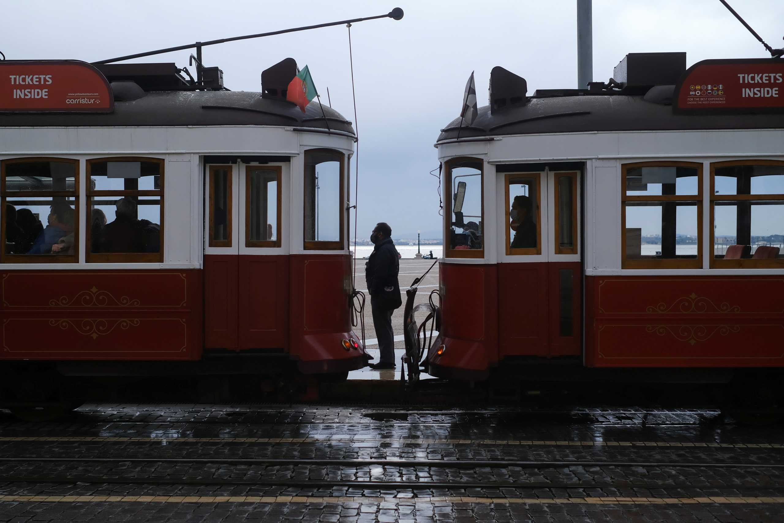 A man wearing a protective mask due to coronavirus disease (COVID-19) pandemic stands between trams in central Lisbon, Portugal, November 25, 2021. REUTERS