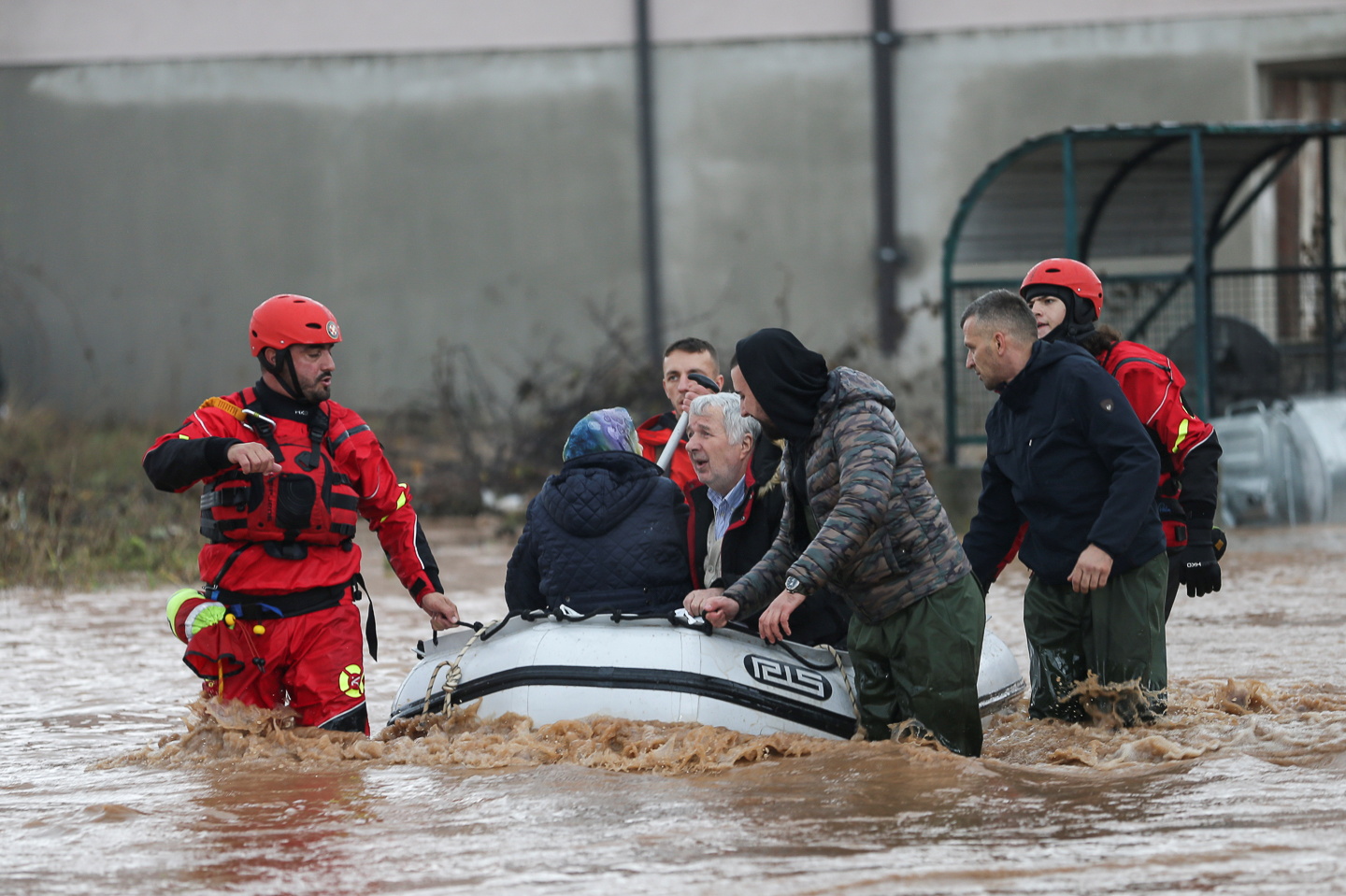 Rescue workers speak with people on a flooded street in Otes near Sarajevo, Bosnia and Herzegovina November 5, 2021. REUTERS