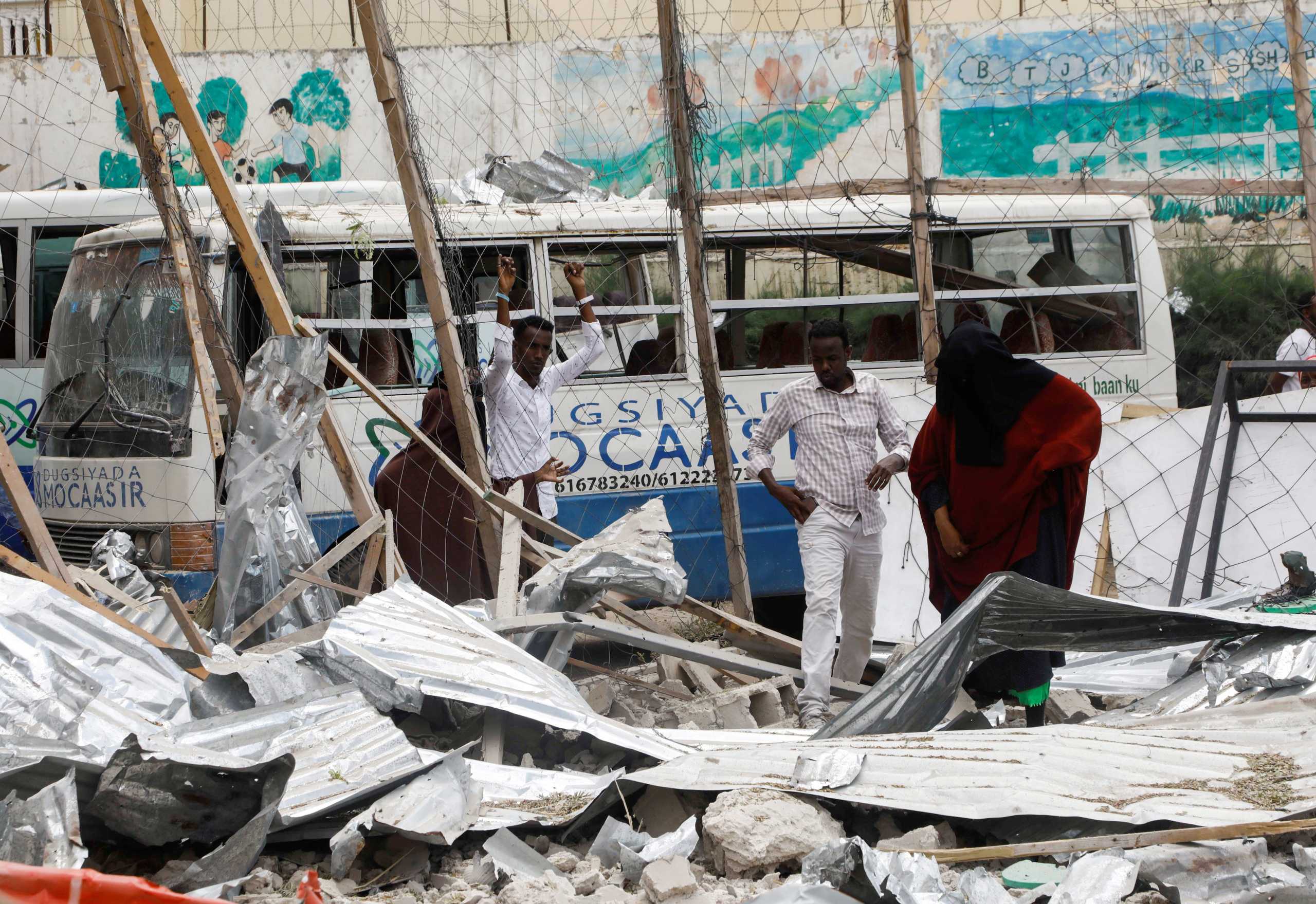 A view shows the damaged structures and school buses, as people inspect the scene, after a car exploded in a suicide attack near Mucassar primary and secondary school in Hodan district of Mogadishu, Somalia November 25, 2021 REUTERS