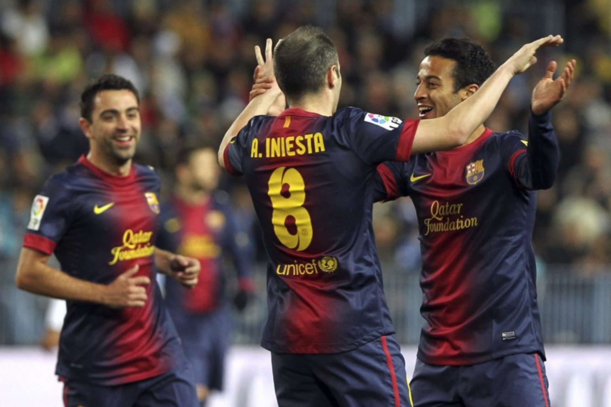 epa03534299 FC Barcelona´s Xavi Hernandez (L) and Andres Iniesta (C) congratulate Thiago Alcantara after scoring the third goal against Malaga during their Spanish Liga's Primera Division soccer match played at La Rosaleda stadium in Malaga, southern Spain, on 13 January 2013.  EPA