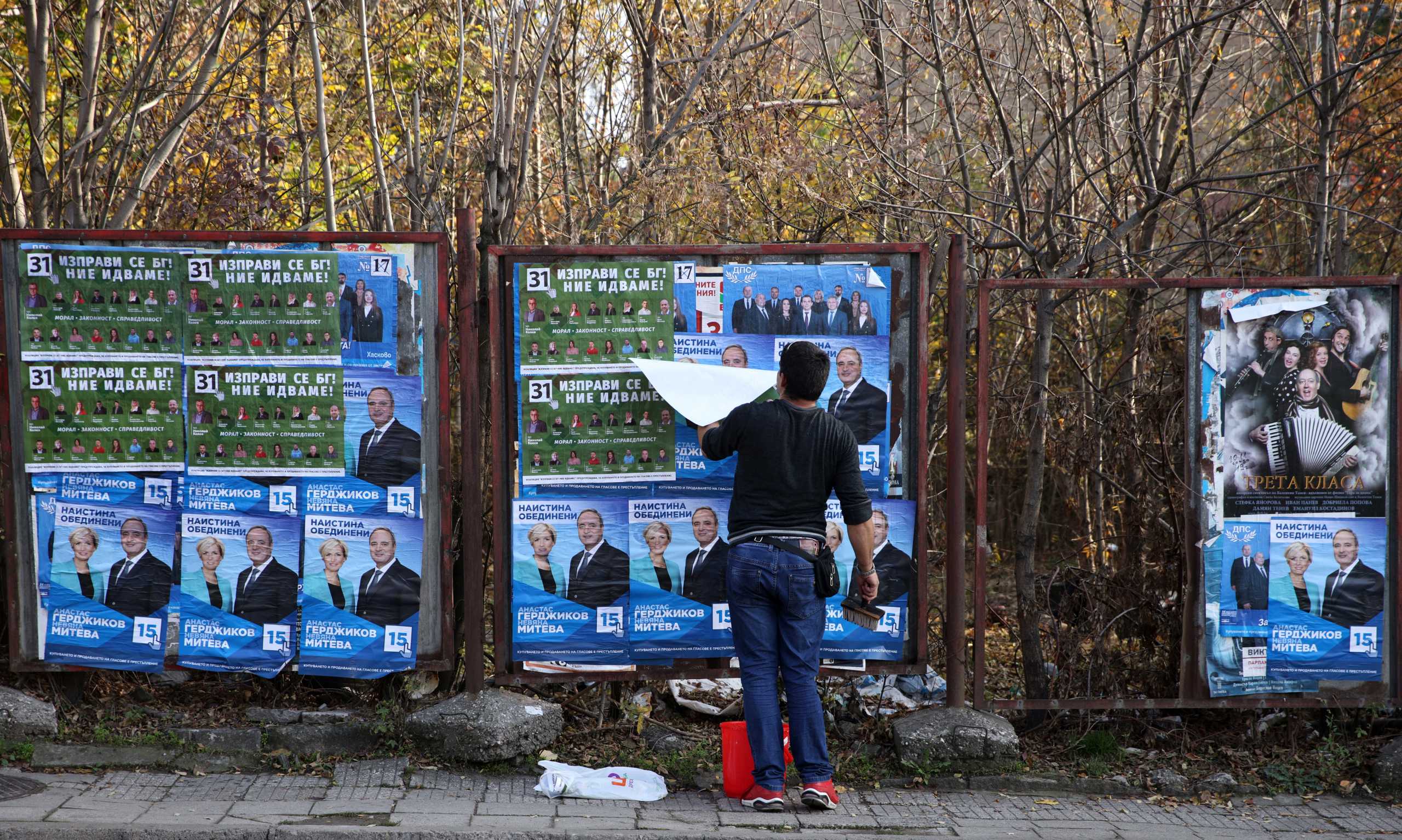A man pastes election posters in Haskovo, Bulgaria, November 8, 2021. Picture taken November 8, 2021. REUTERS