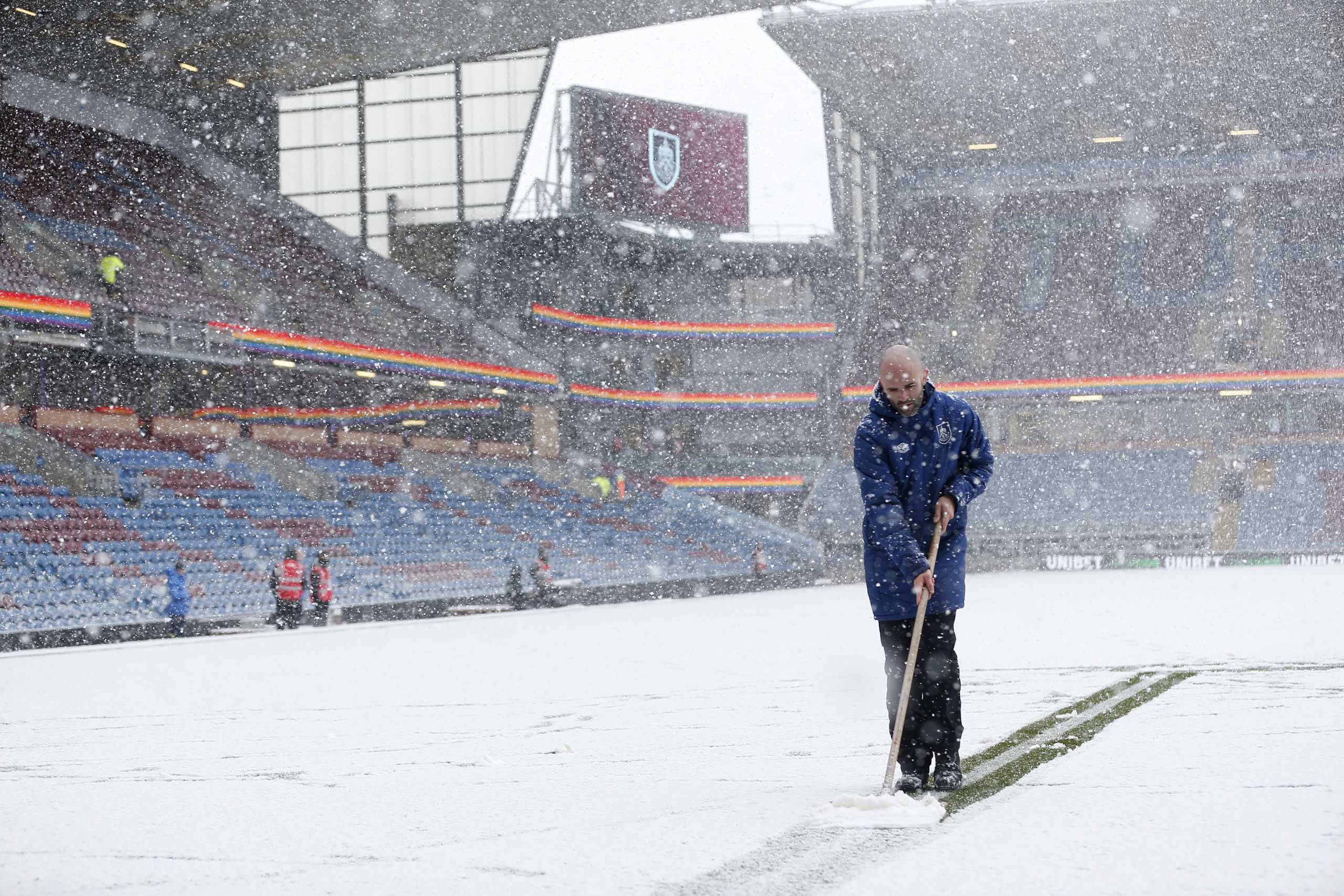 Soccer Football - Premier League - Burnley v Tottenham Hotspur - Turf Moor, Burnley, Britain - November 28, 2021 General view as a member of ground staff clears snow off the pitch before the match REUTERS