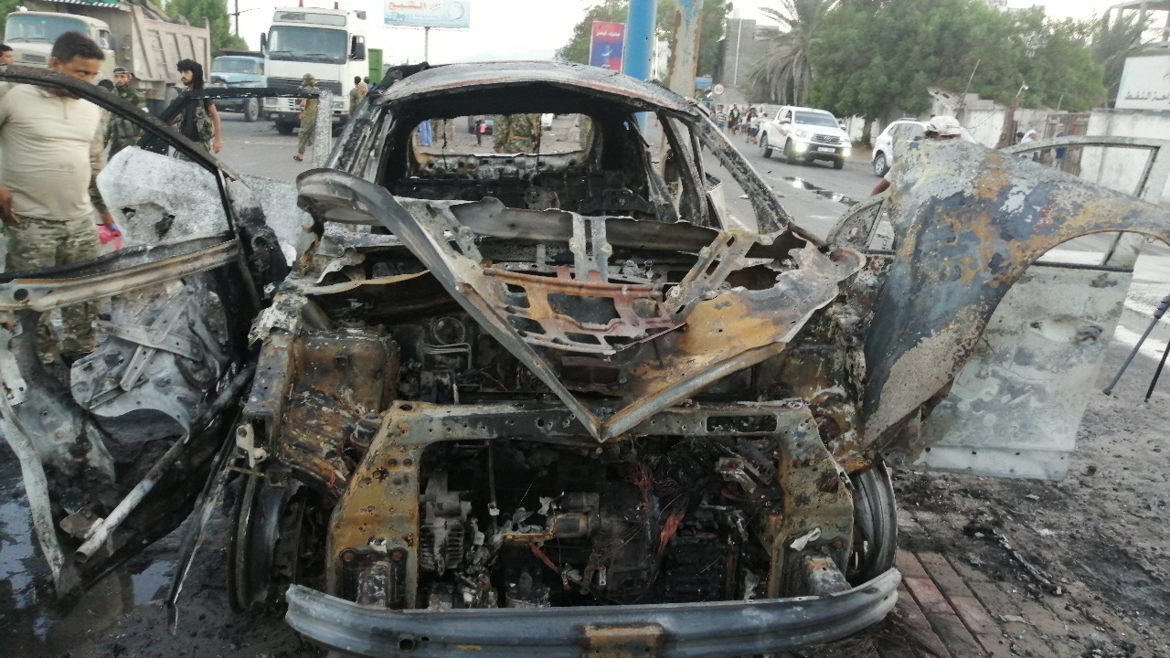A security man inspects the wreckage of a car at the site of an explosion that killed a journalist in Aden, Yemen November 9, 2021. REUTERS