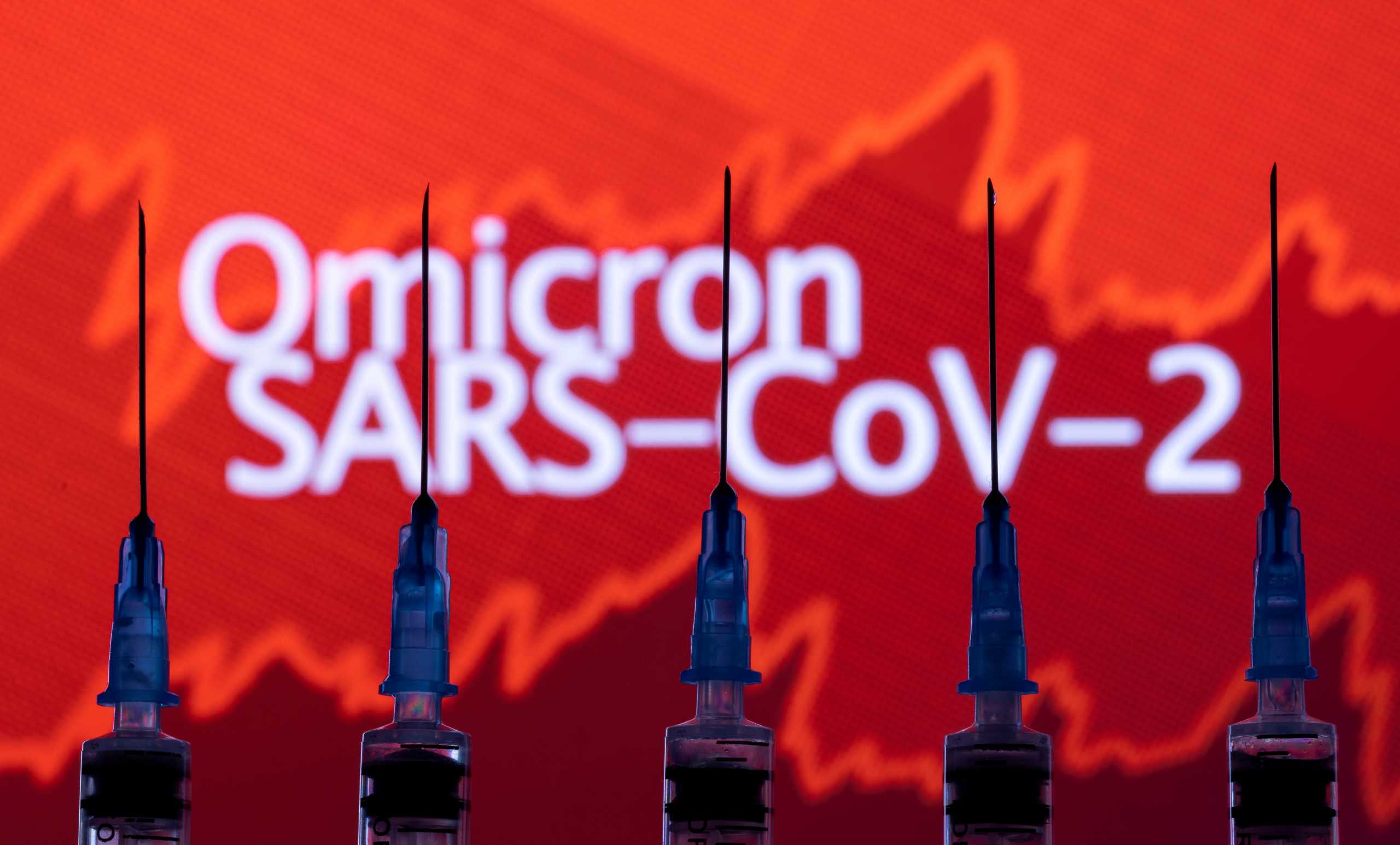 FILE PHOTO: Syringes with needles are seen in front of a displayed stock graph and words "Omicron SARS-CoV-2" in this illustration taken, November 27, 2021. REUTERS