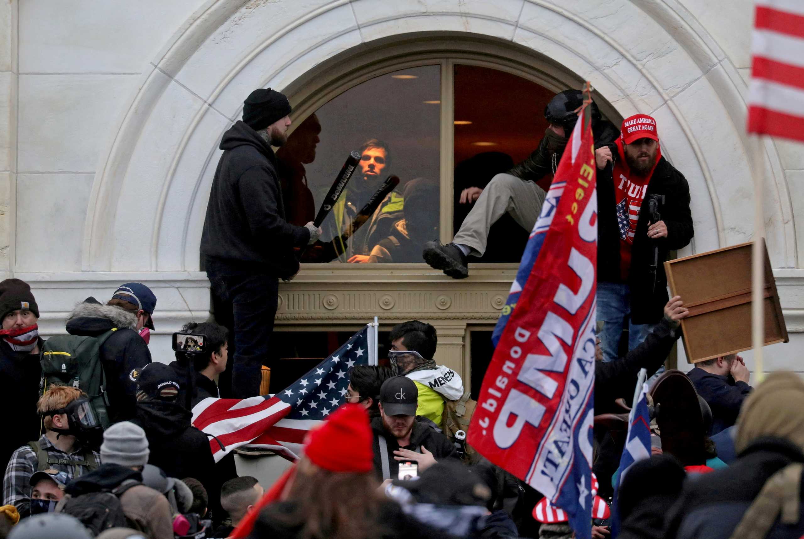 FILE PHOTO: A mob of supporters of then-U.S. President Donald Trump climb through a window they broke as they storm the U.S. Capitol Building in Washington, U.S., January 6, 2021. REUTERS