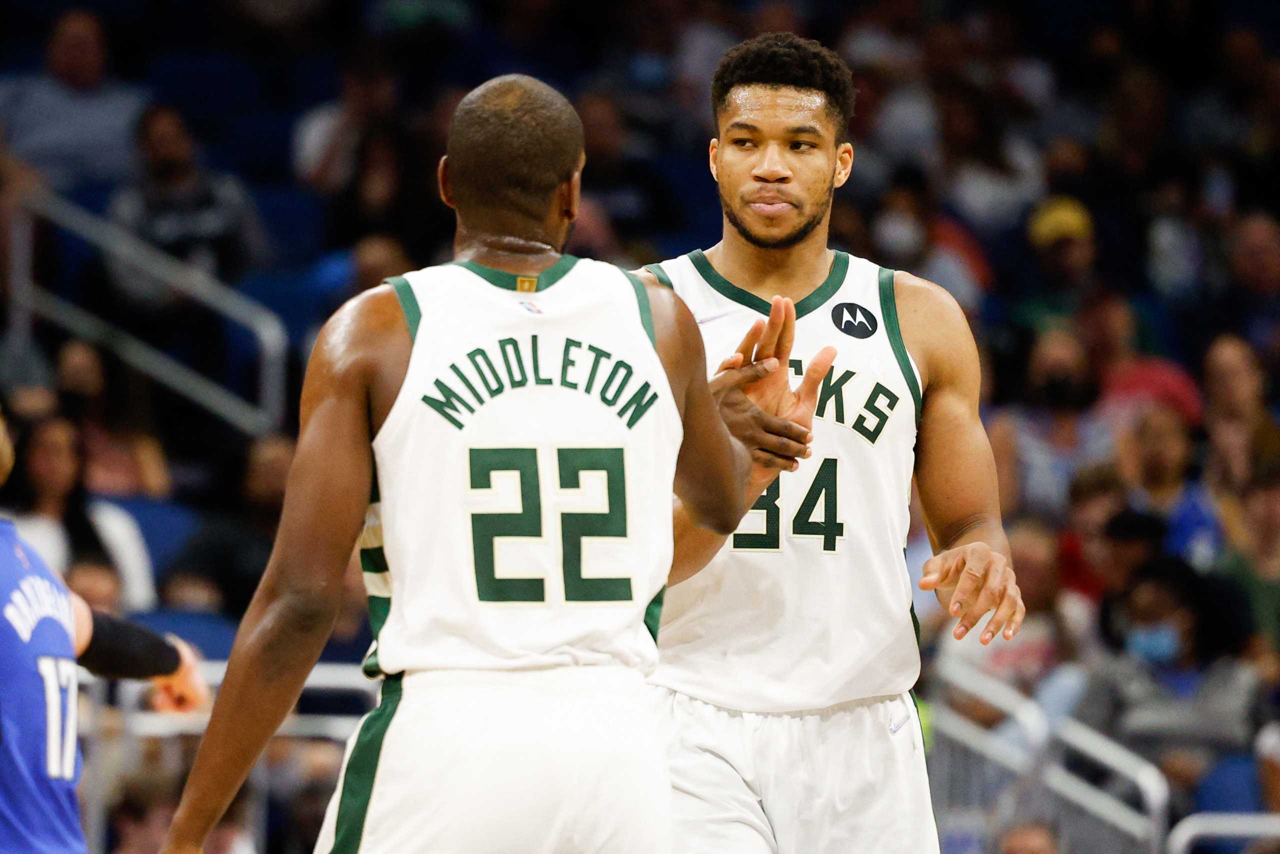 Dec 30, 2021; Orlando, Florida, USA; Milwaukee Bucks forward Khris Middleton (22) and forward Giannis Antetokounmpo (34) celebrate a three point shot in the second half against the Orlando Magic at Amway Center. Mandatory Credit: Nathan Ray Seebeck-USA TODAY Sports
