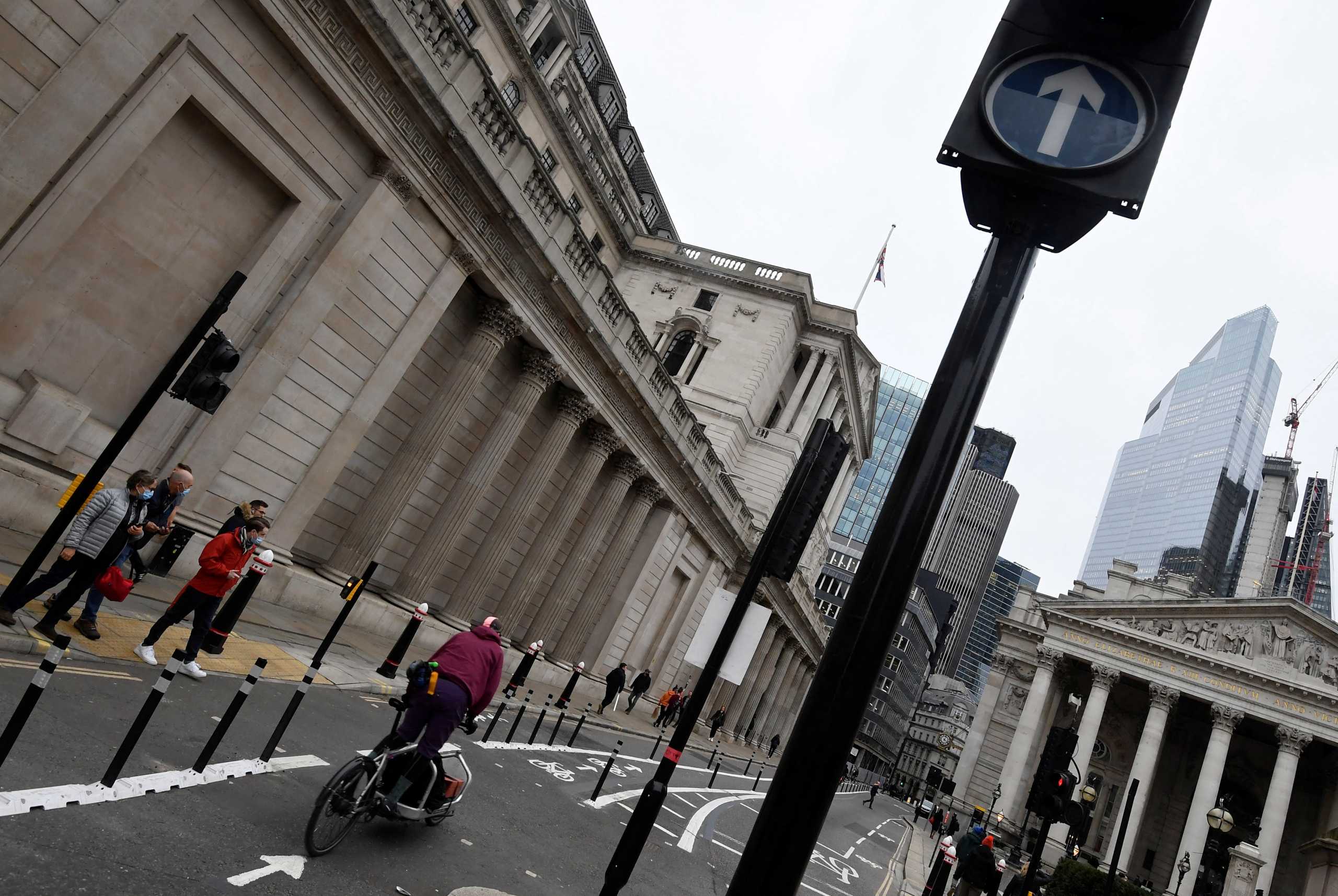 People cross a road in front of the Bank of England (BoE) building after the BoE became the first major world's central bank to raise rates since the coronavirus disease (COVID-19) pandemic, London, Britain, December 16, 2021. REUTERS